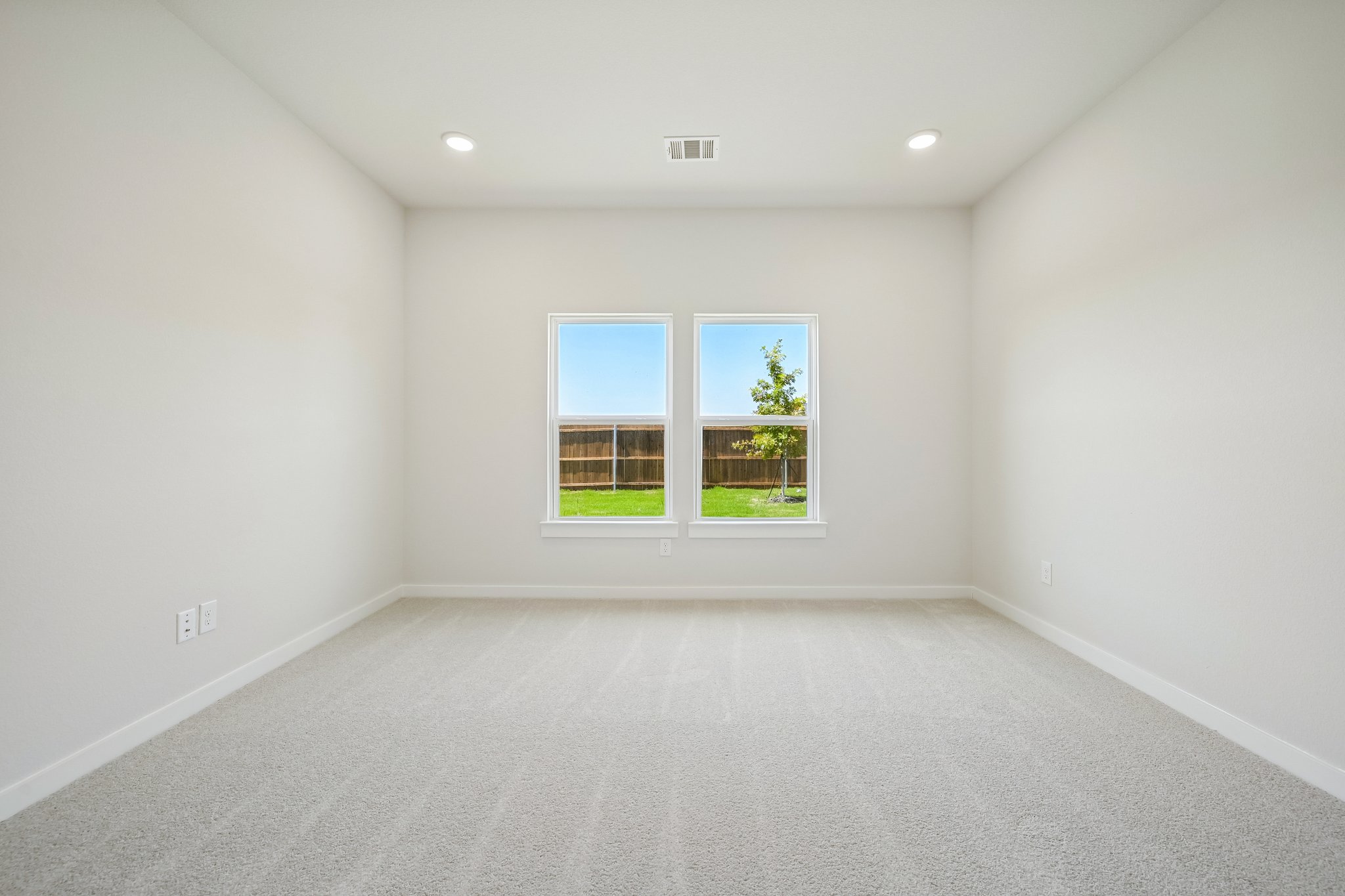A room with a window and a white wall.