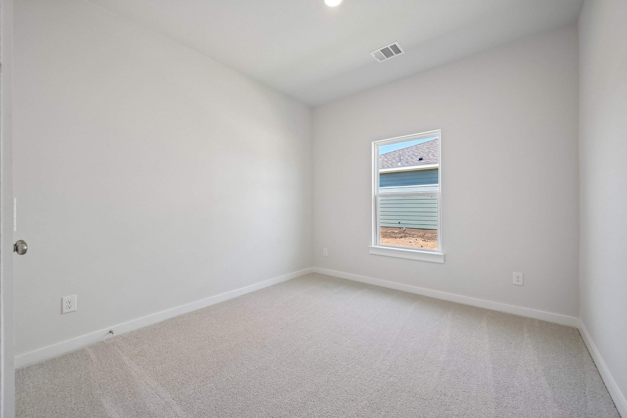 A room with a window and a carpet.