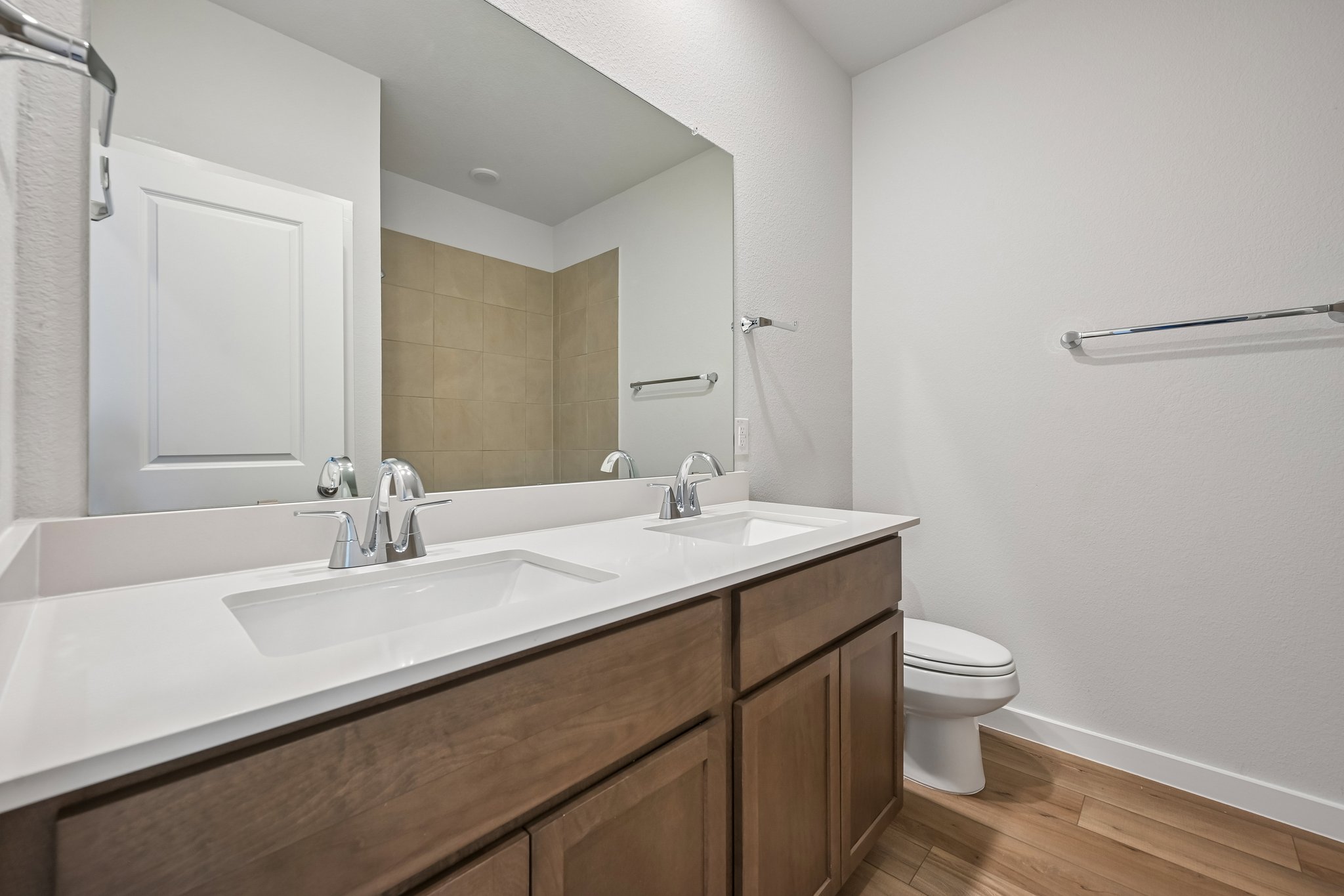 A bathroom with a sink toilet and mirror.