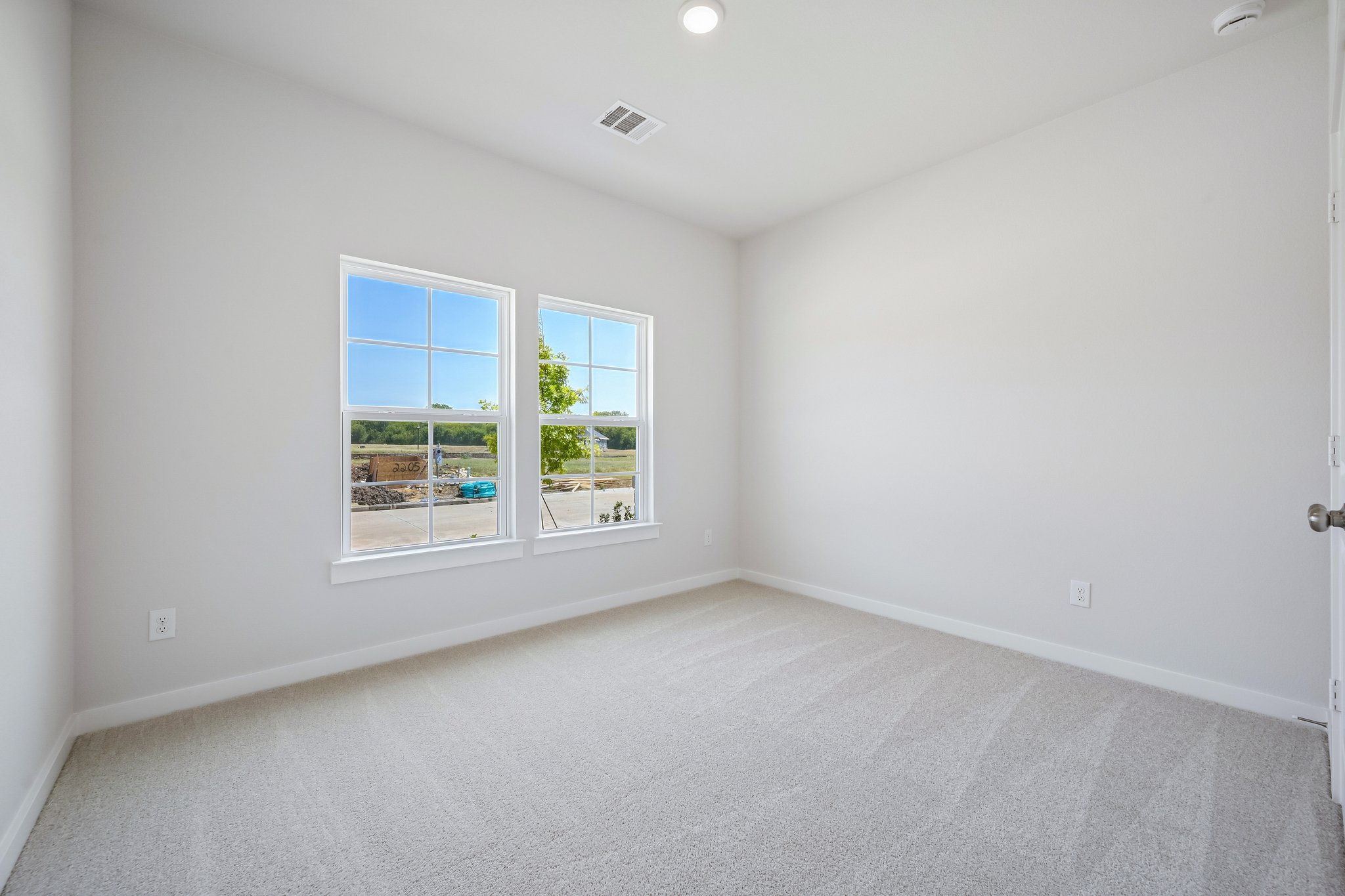 A room with a window and a white wall.