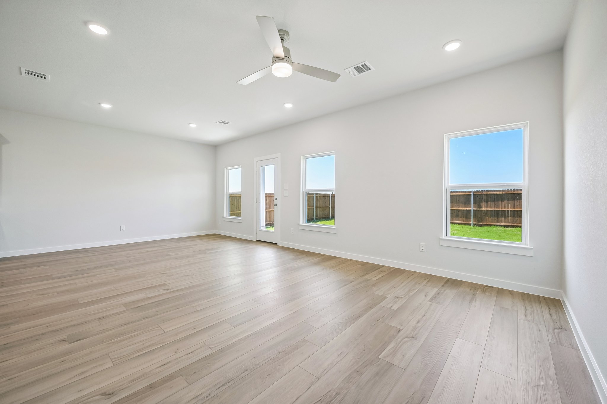 A room with a wood floor and a ceiling fan.
