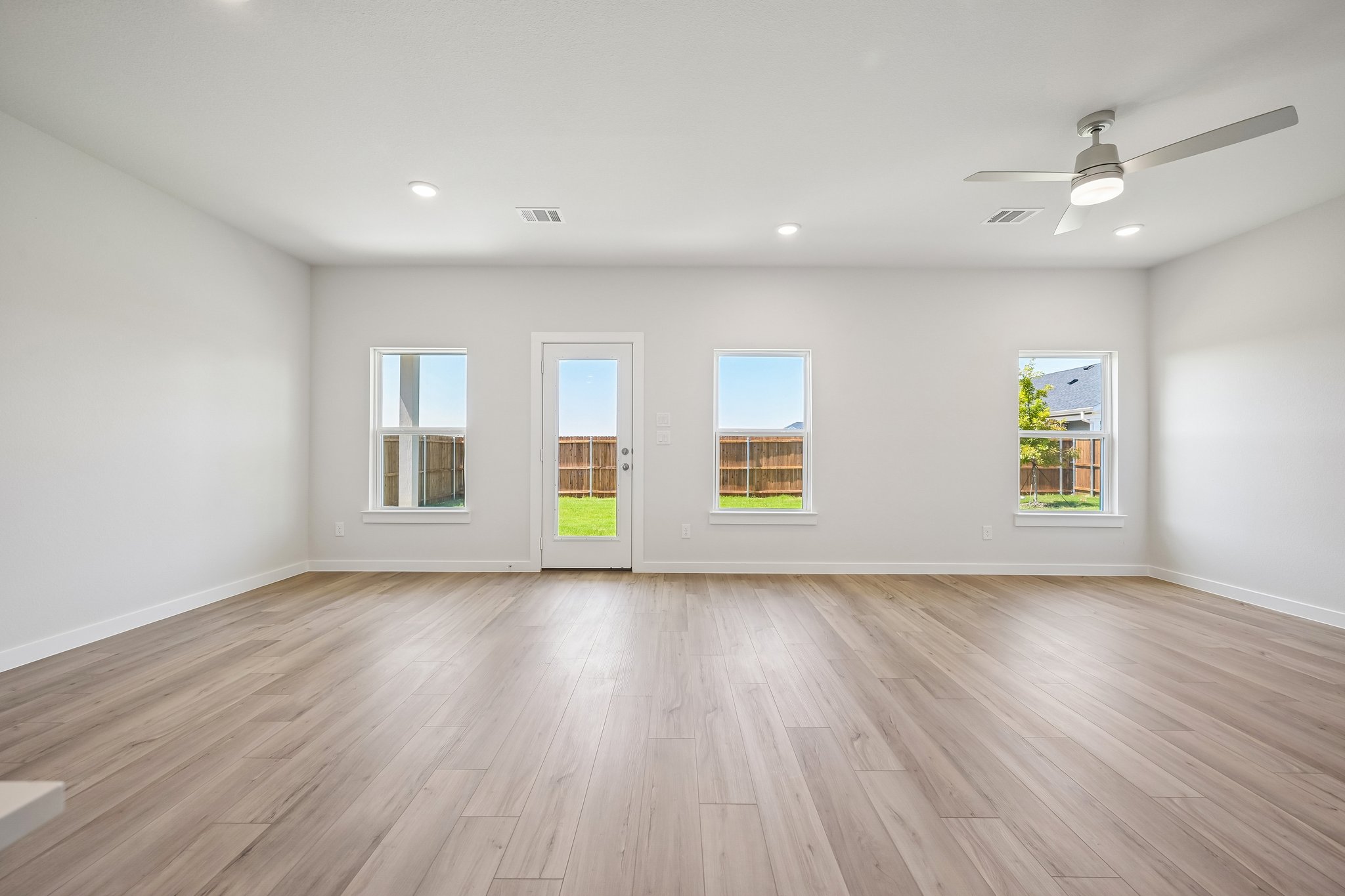 A room with a wood floor and windows.