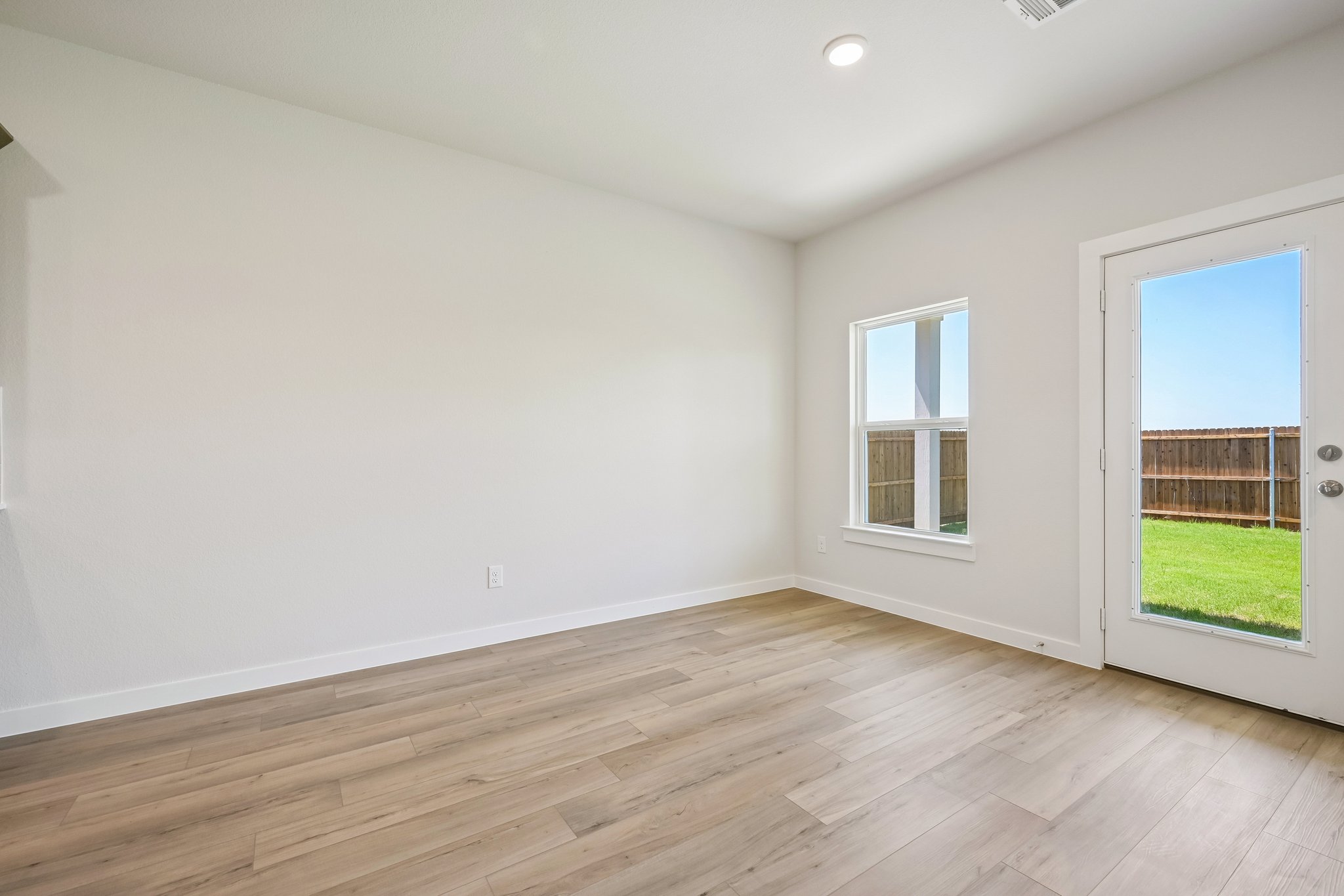 A room with a wood floor and windows.