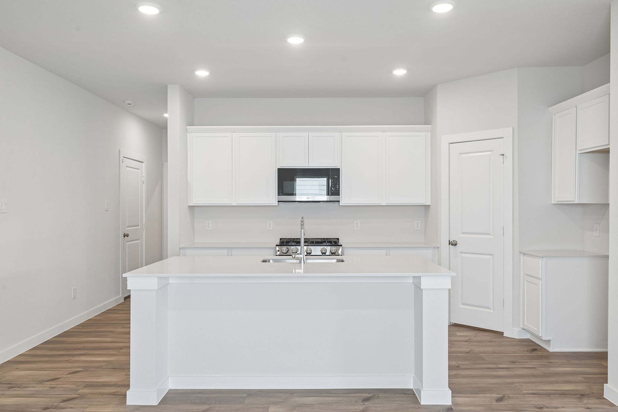 A kitchen with white cabinets.