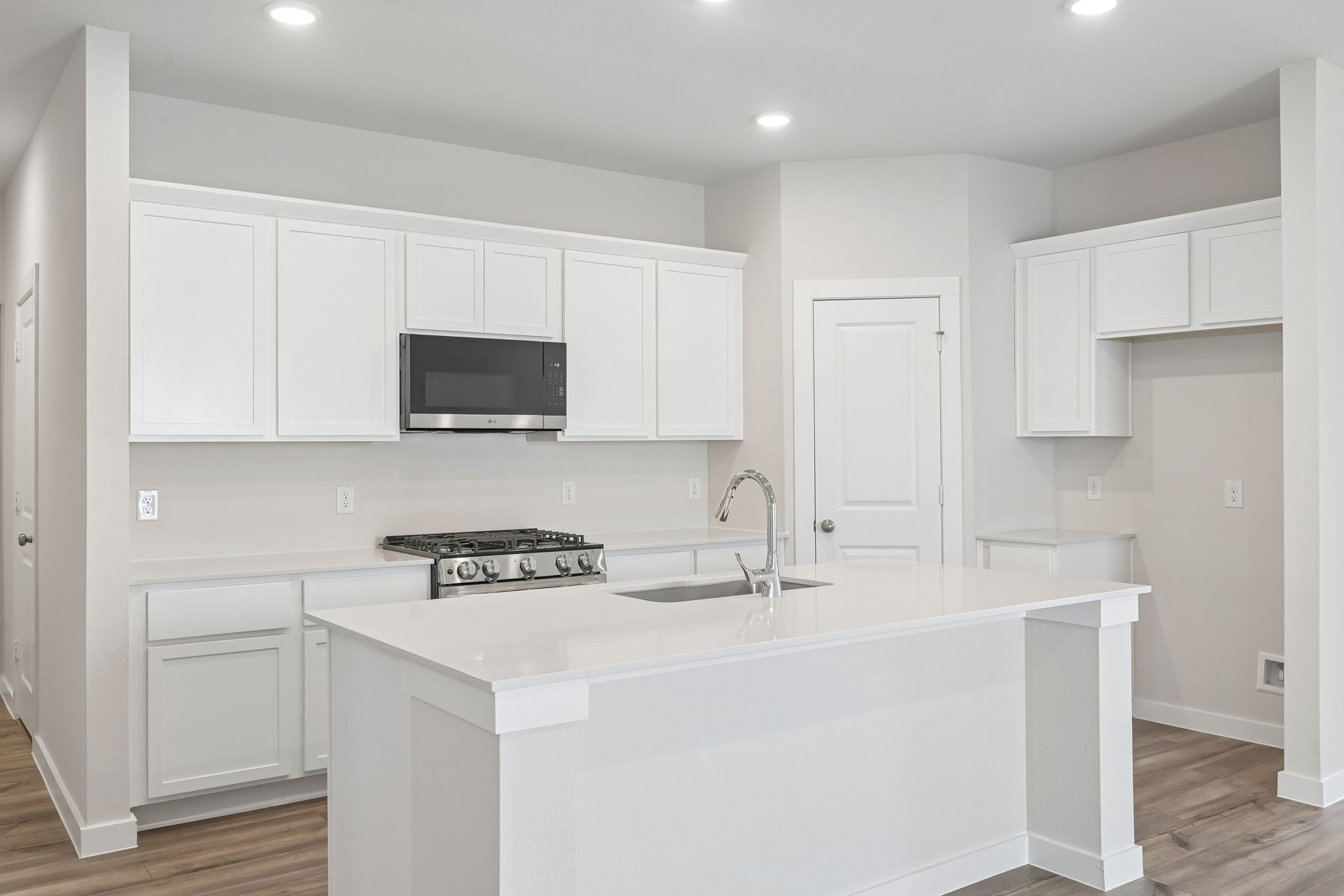 A kitchen with white cabinets.