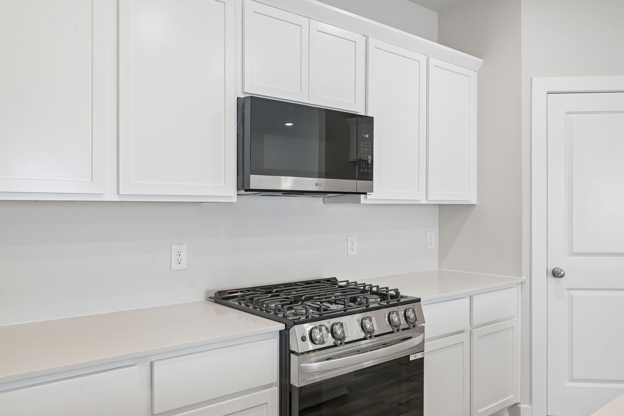 A kitchen with white cabinets.