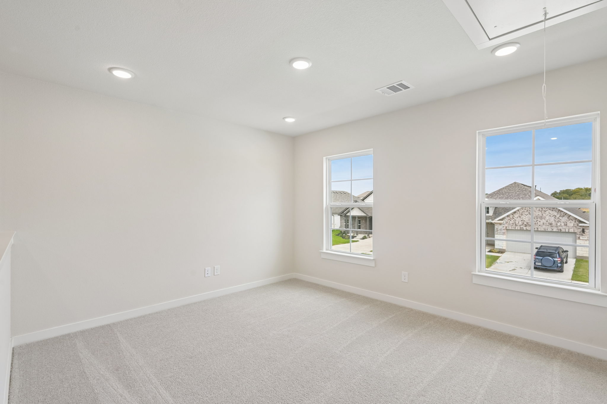 A room with a window and a white wall with a white carpet.