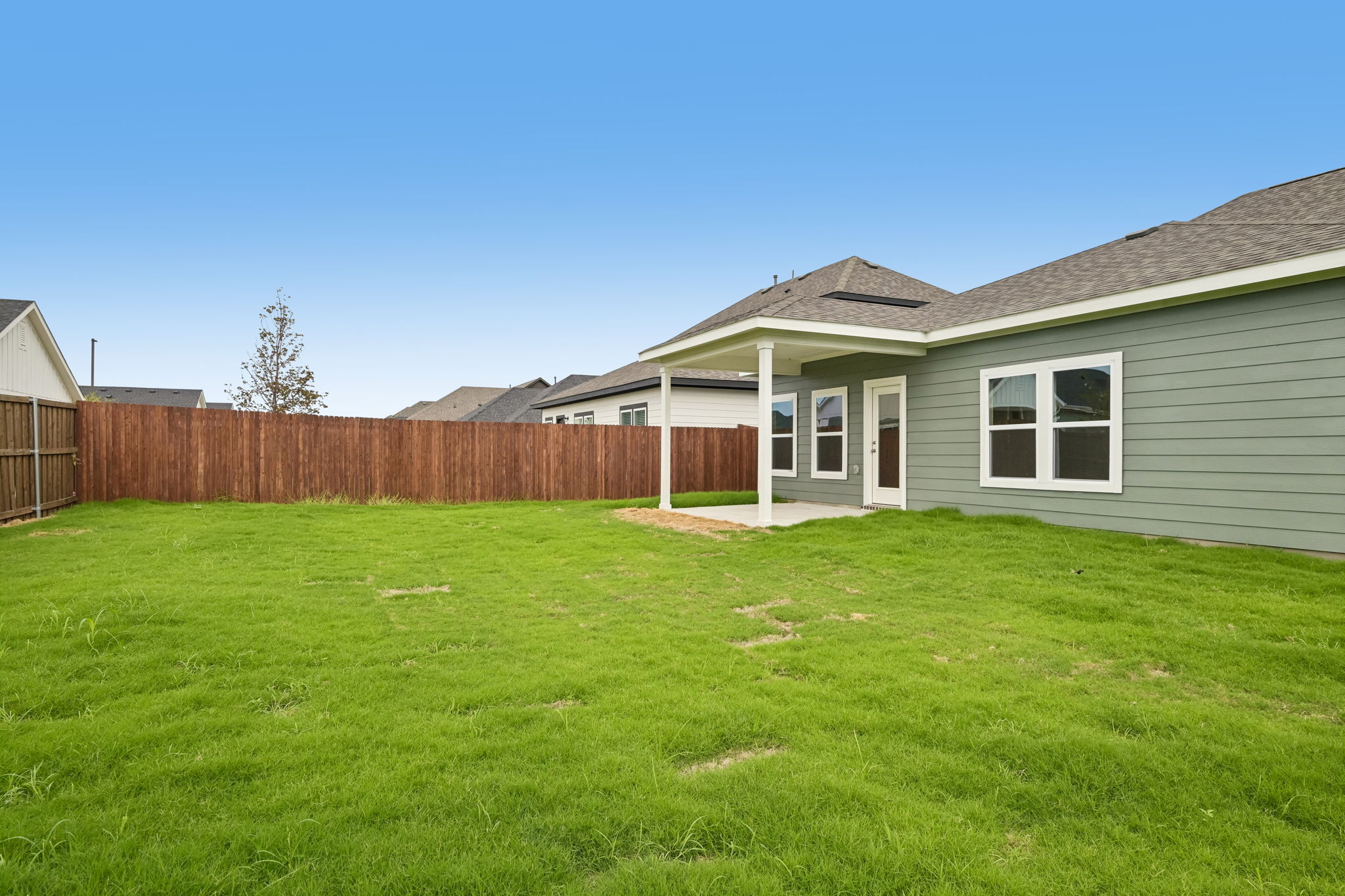 A house with a fence and grass.