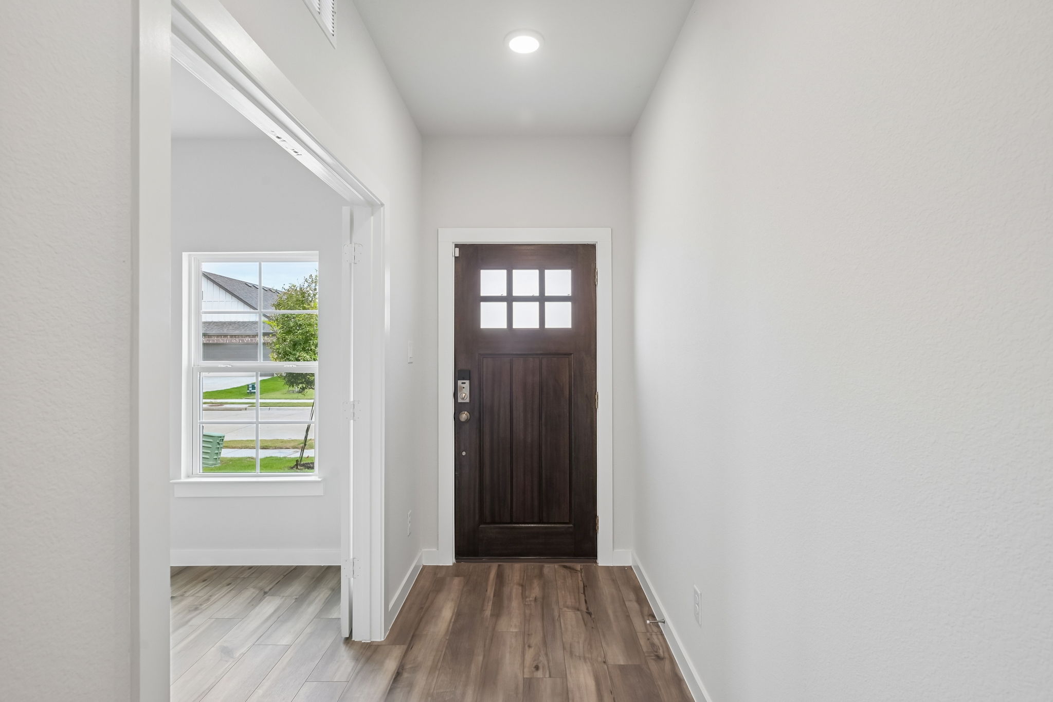 A room with a wood floor and a door with a window.