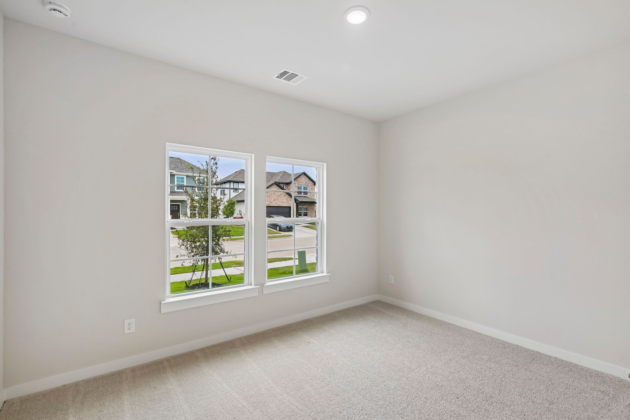 A room with a window and a white wall.