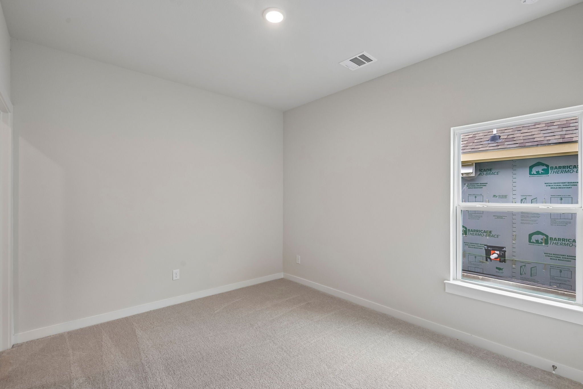 A room with a white wall and a white wall with a poster on it.