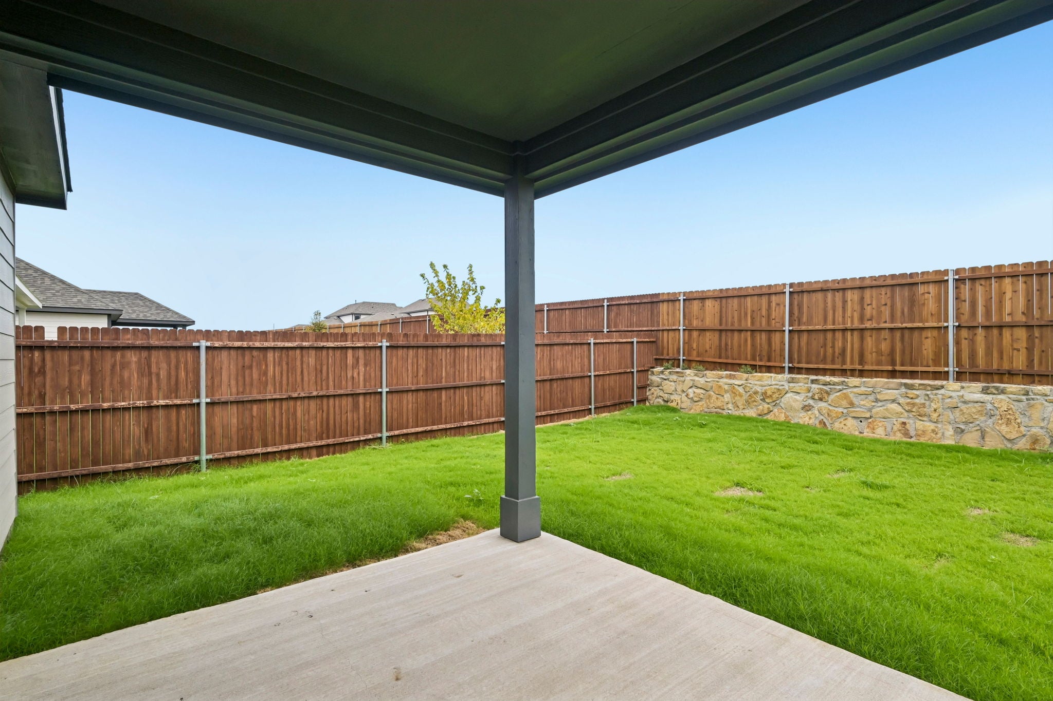 A fenced in yard with a wood walkway and a wood fence.