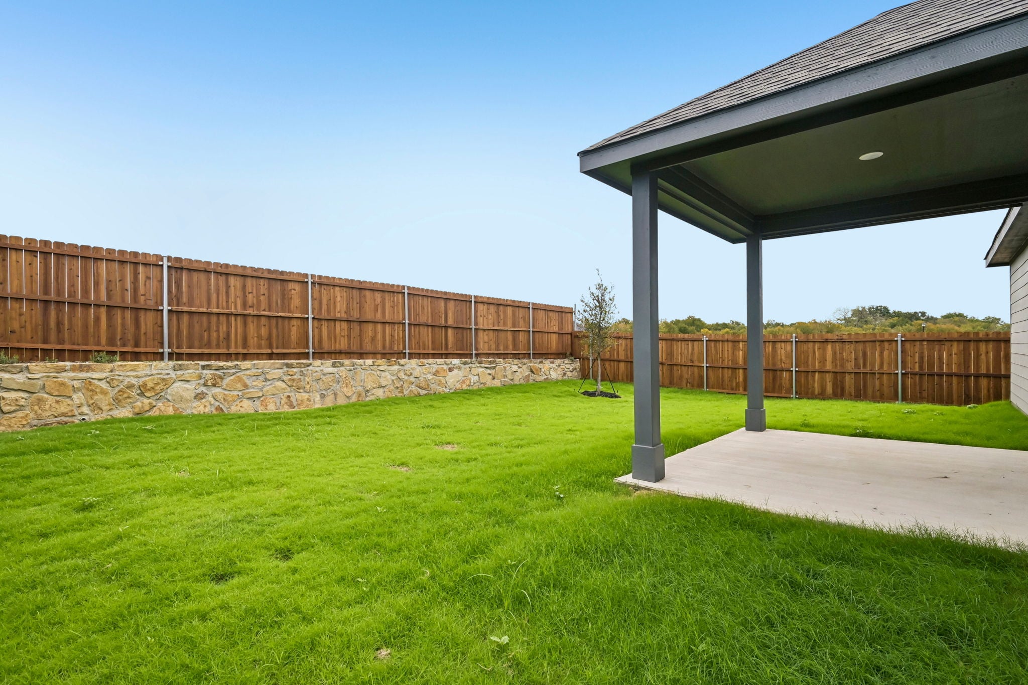 A fenced in yard with a building in the background.
