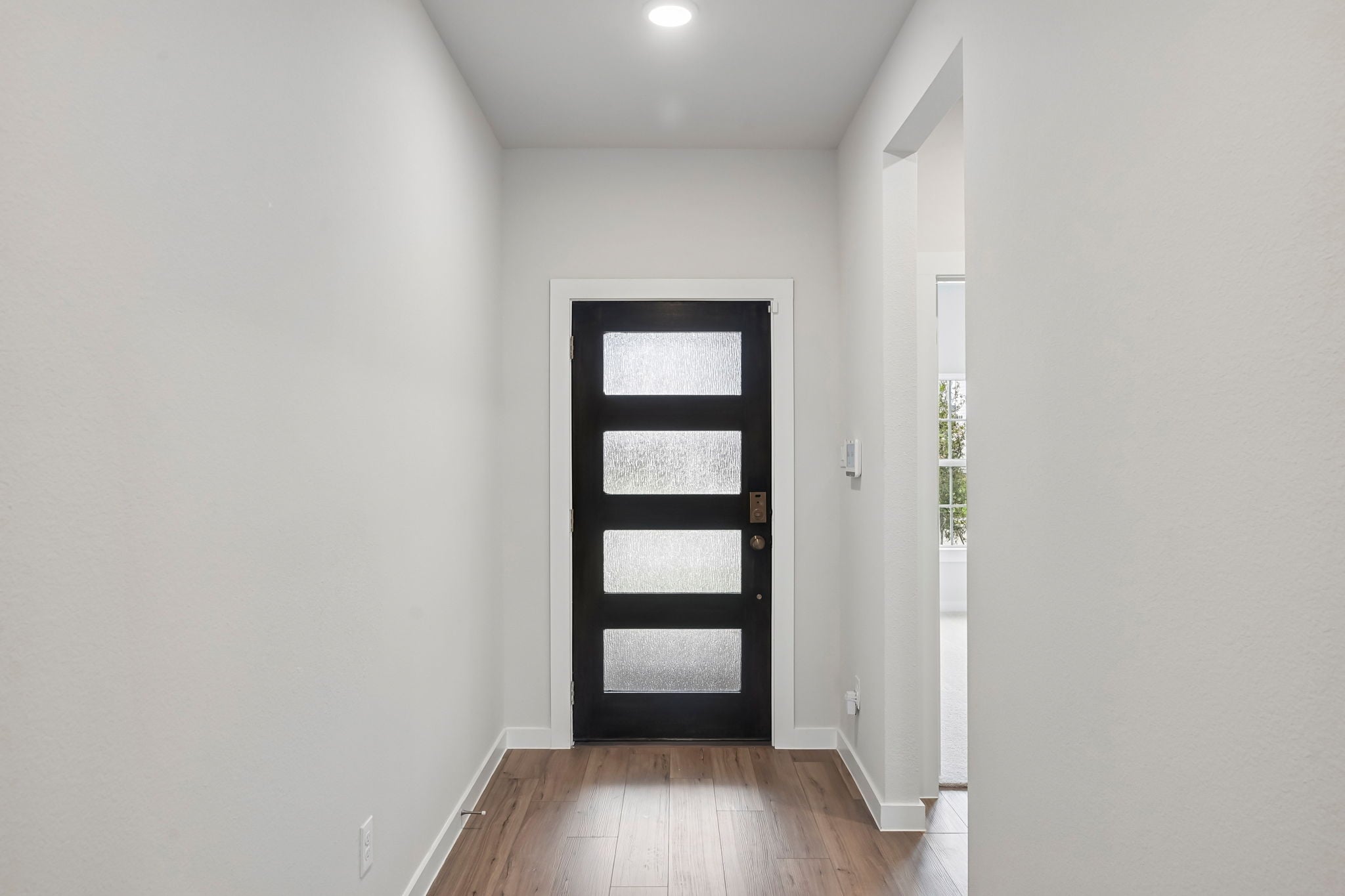 A hallway with a wood floor.