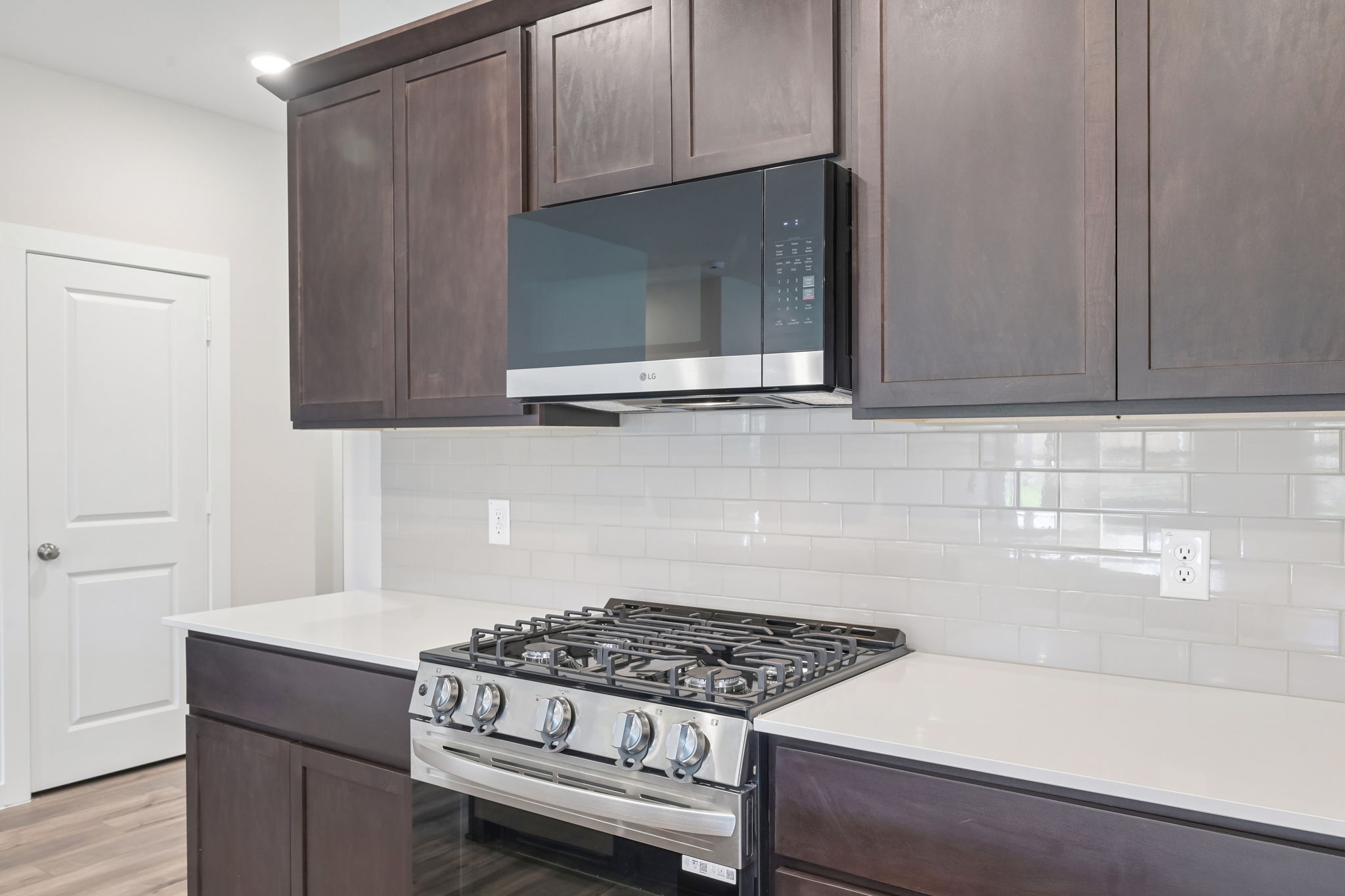 A kitchen with a stove and microwave.