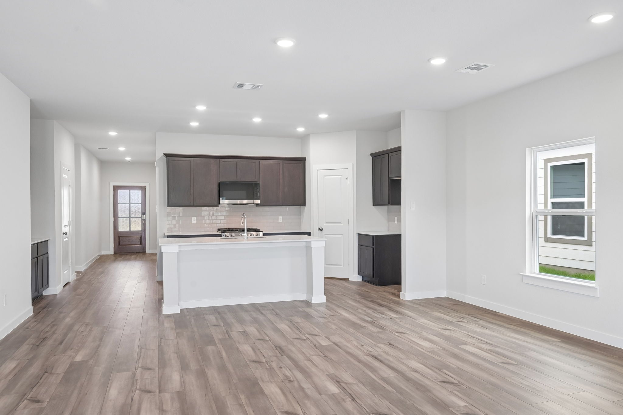 A large kitchen with a wood floor.