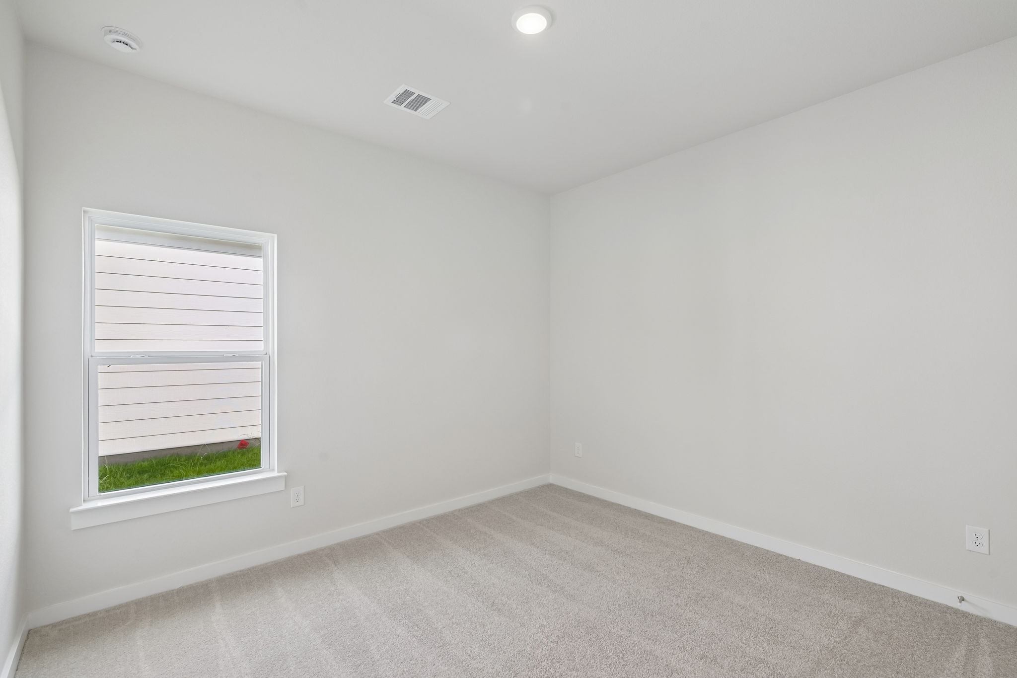 A room with a window and a carpet.