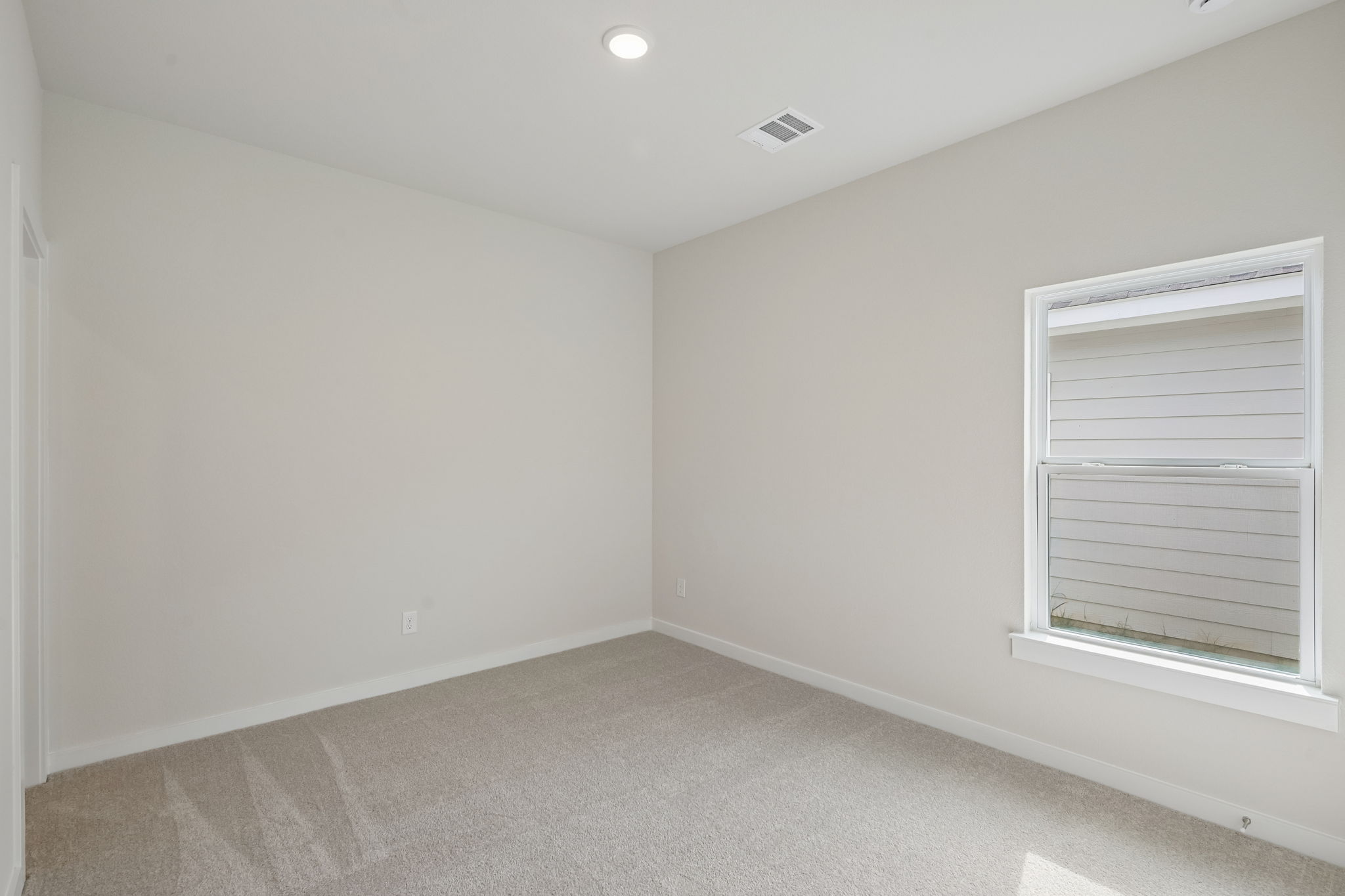 A room with a window and a carpet.