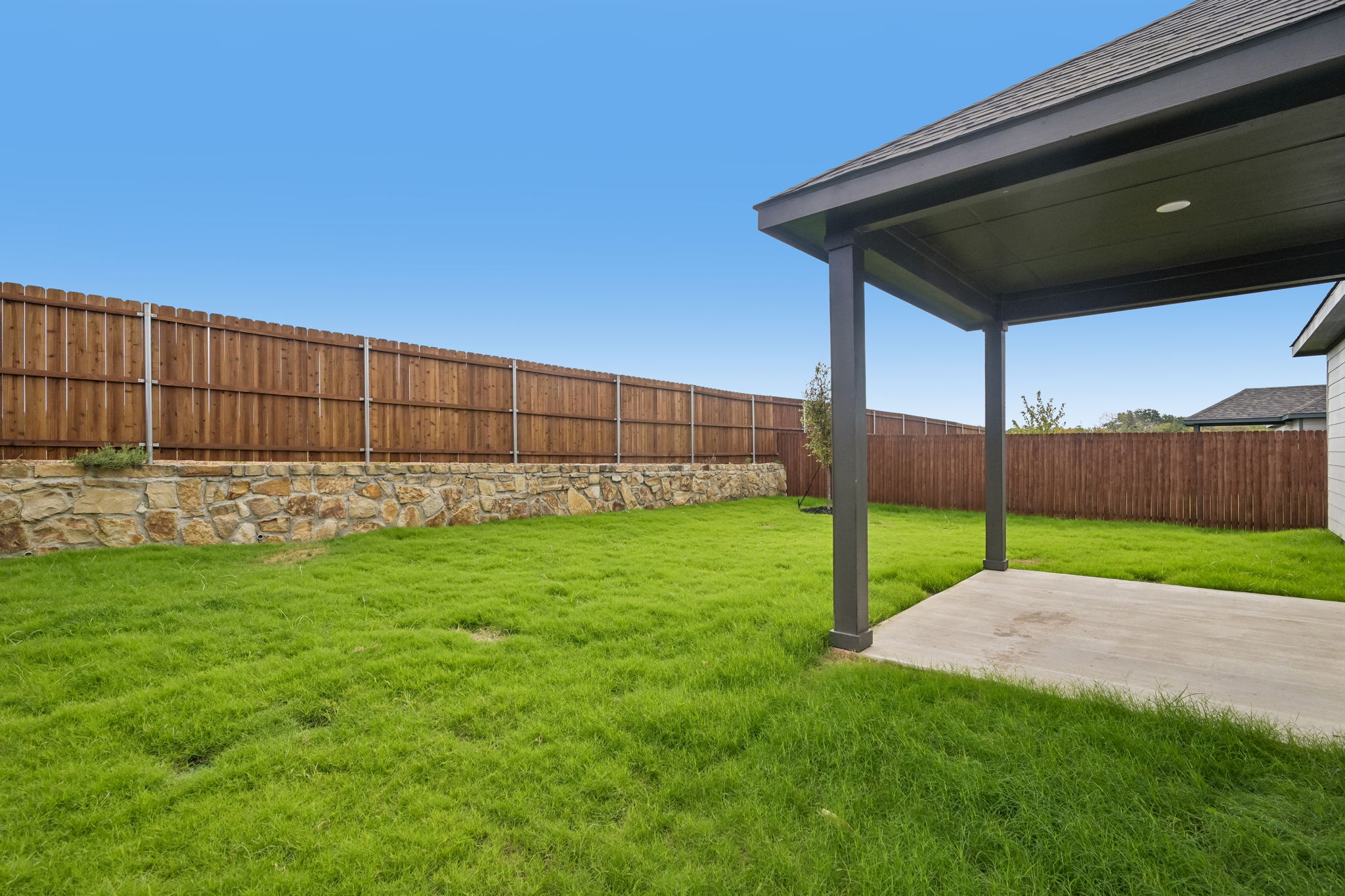 A fenced in yard with a building in the background.