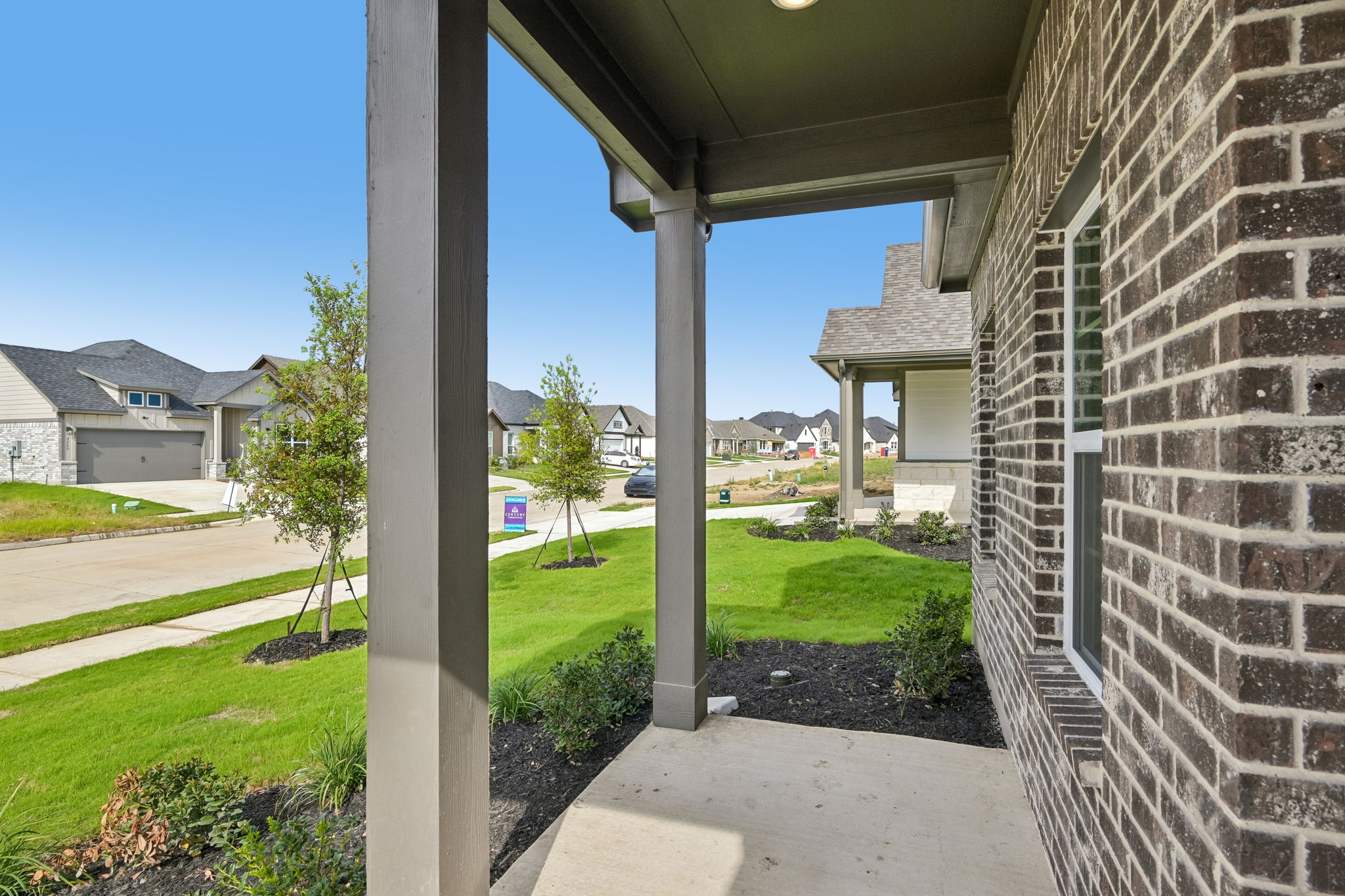 A view of a yard and a house from a porch.