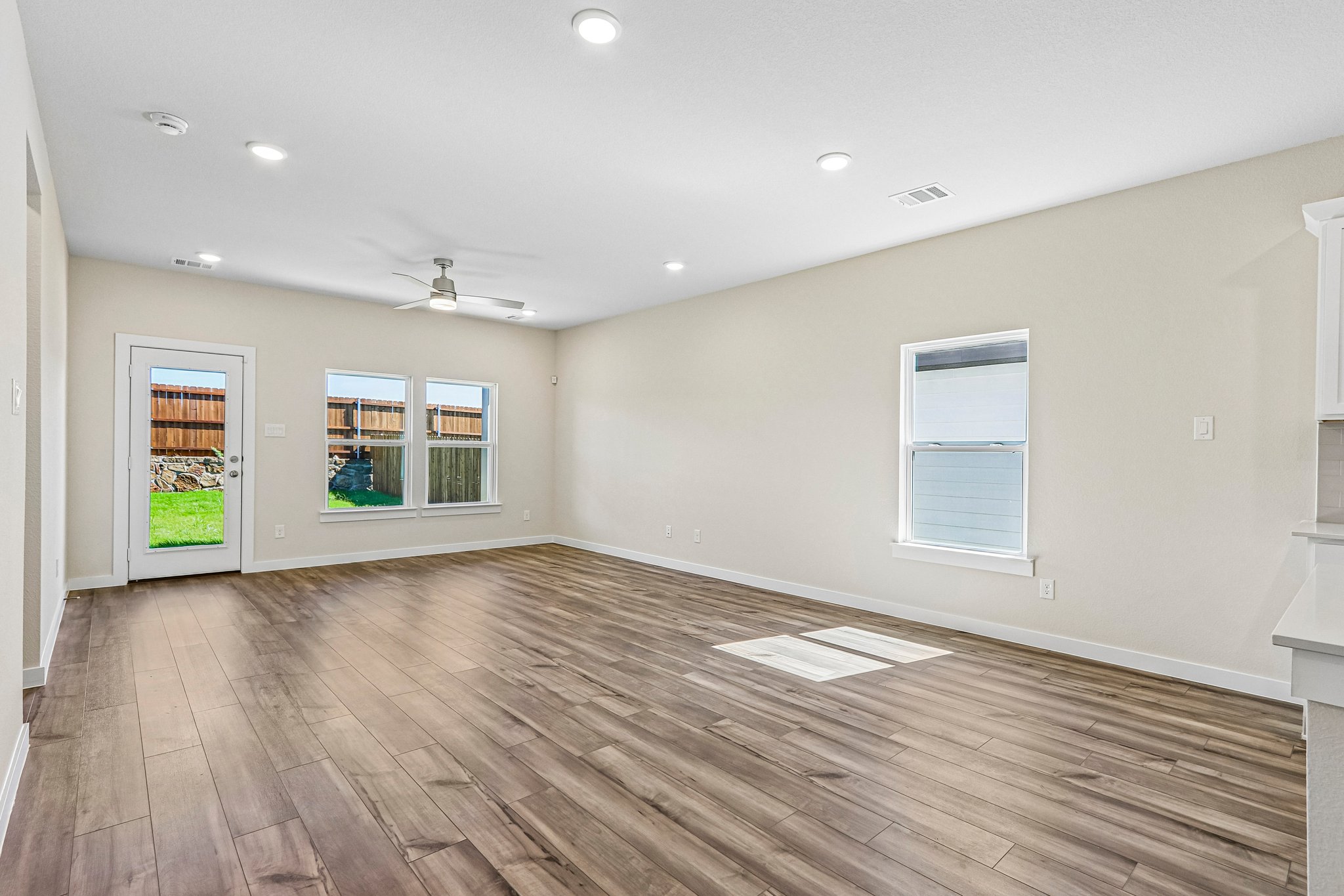 A room with a wood floor and windows.
