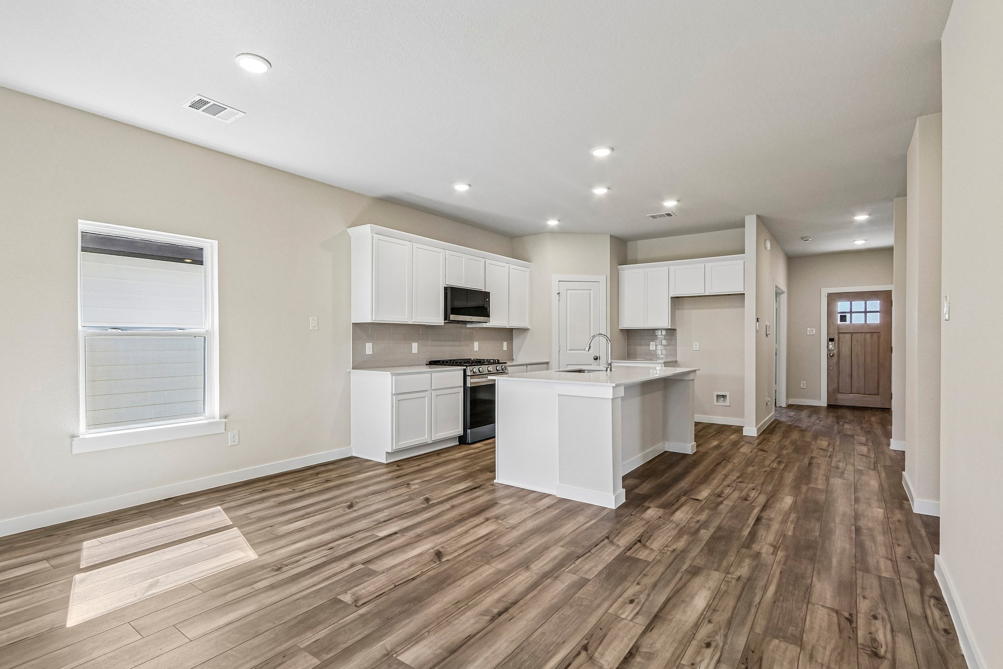 A kitchen with white cabinets.