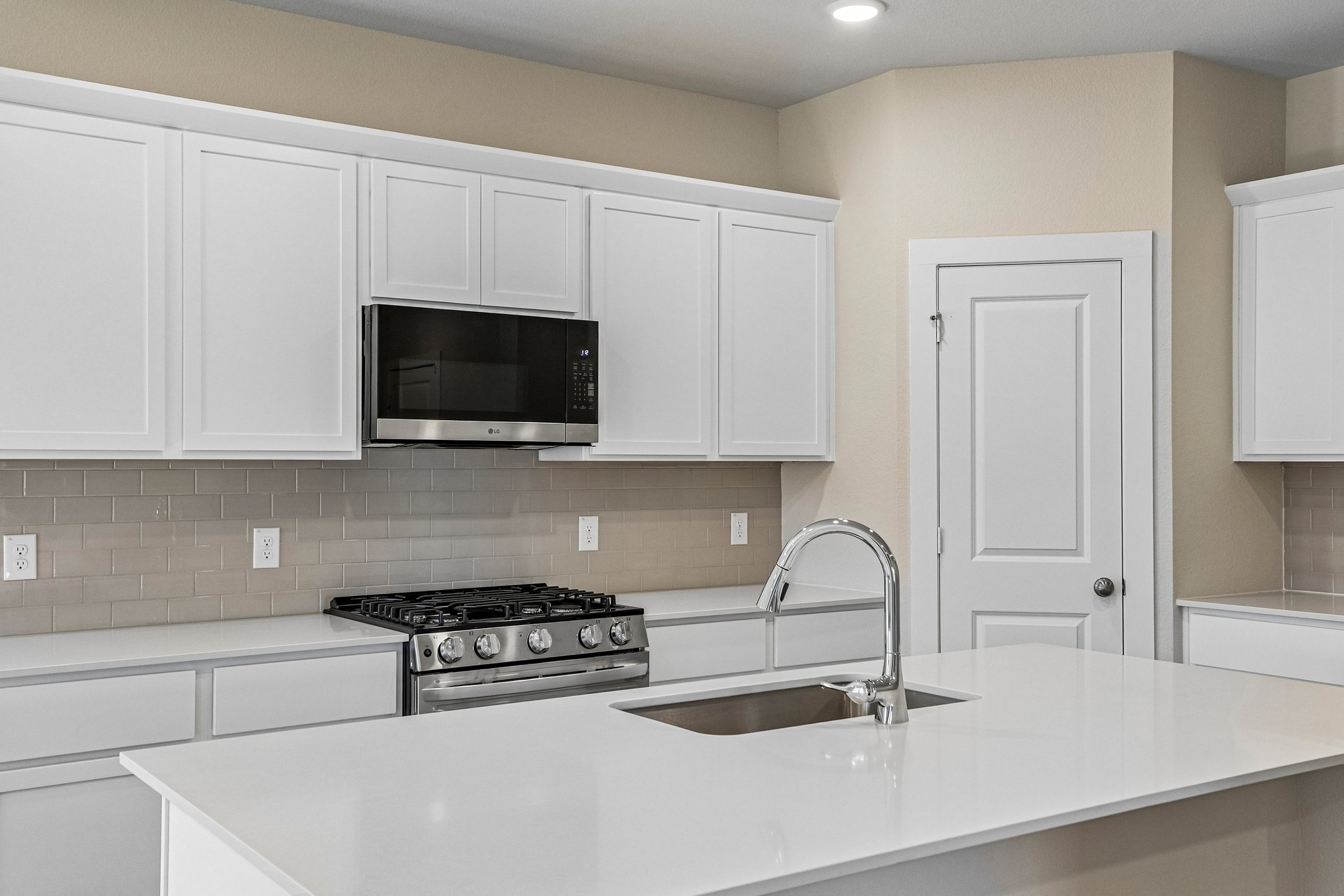 A kitchen with white cabinets.