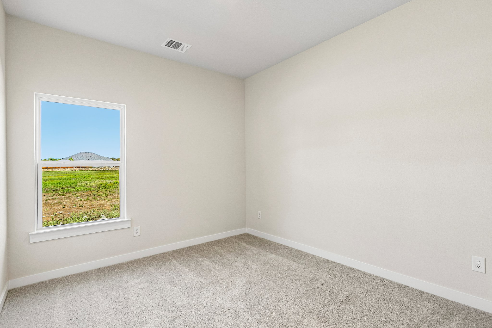 A room with a window and a carpet.