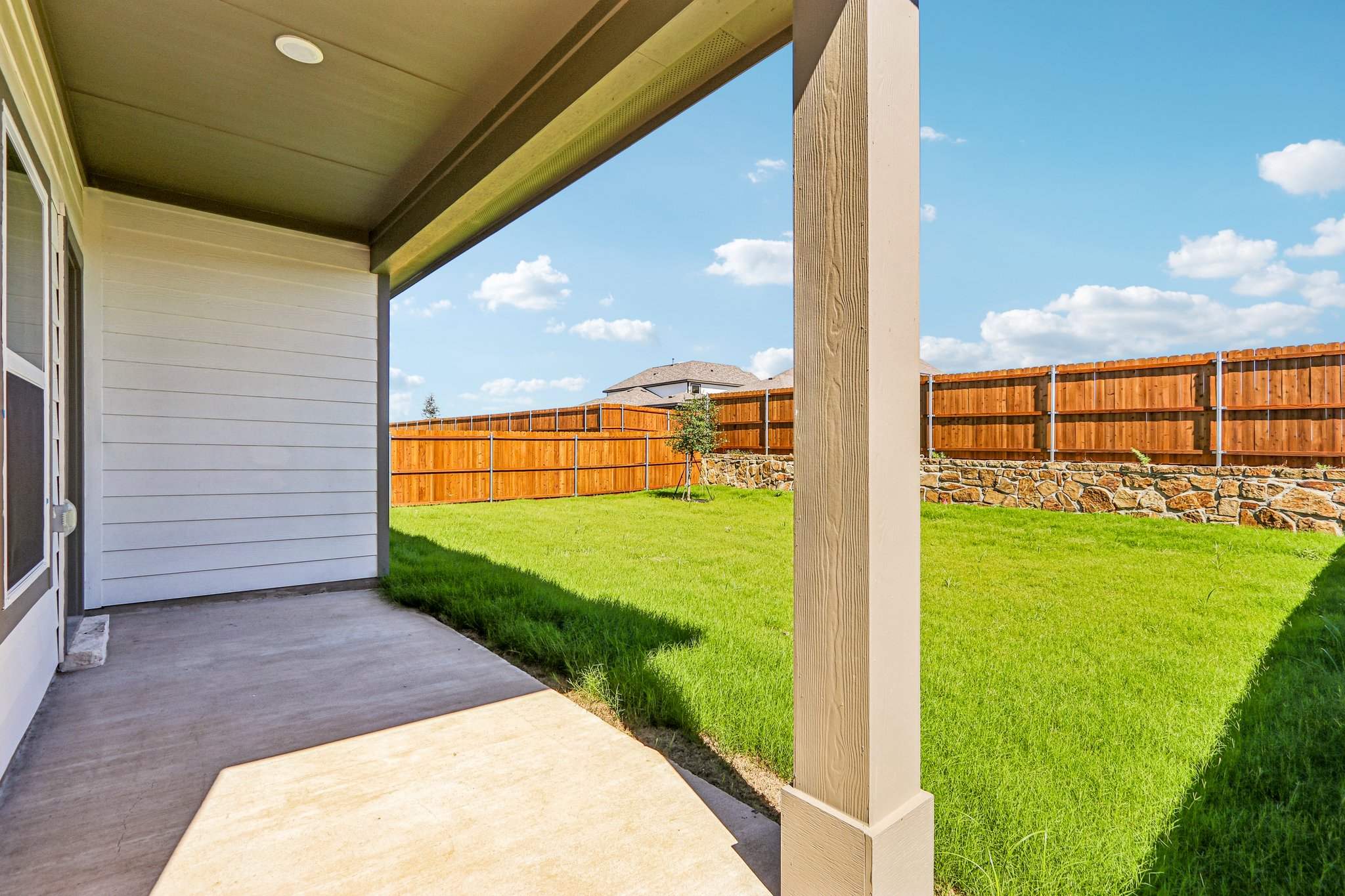 A backyard with a fence and grass.
