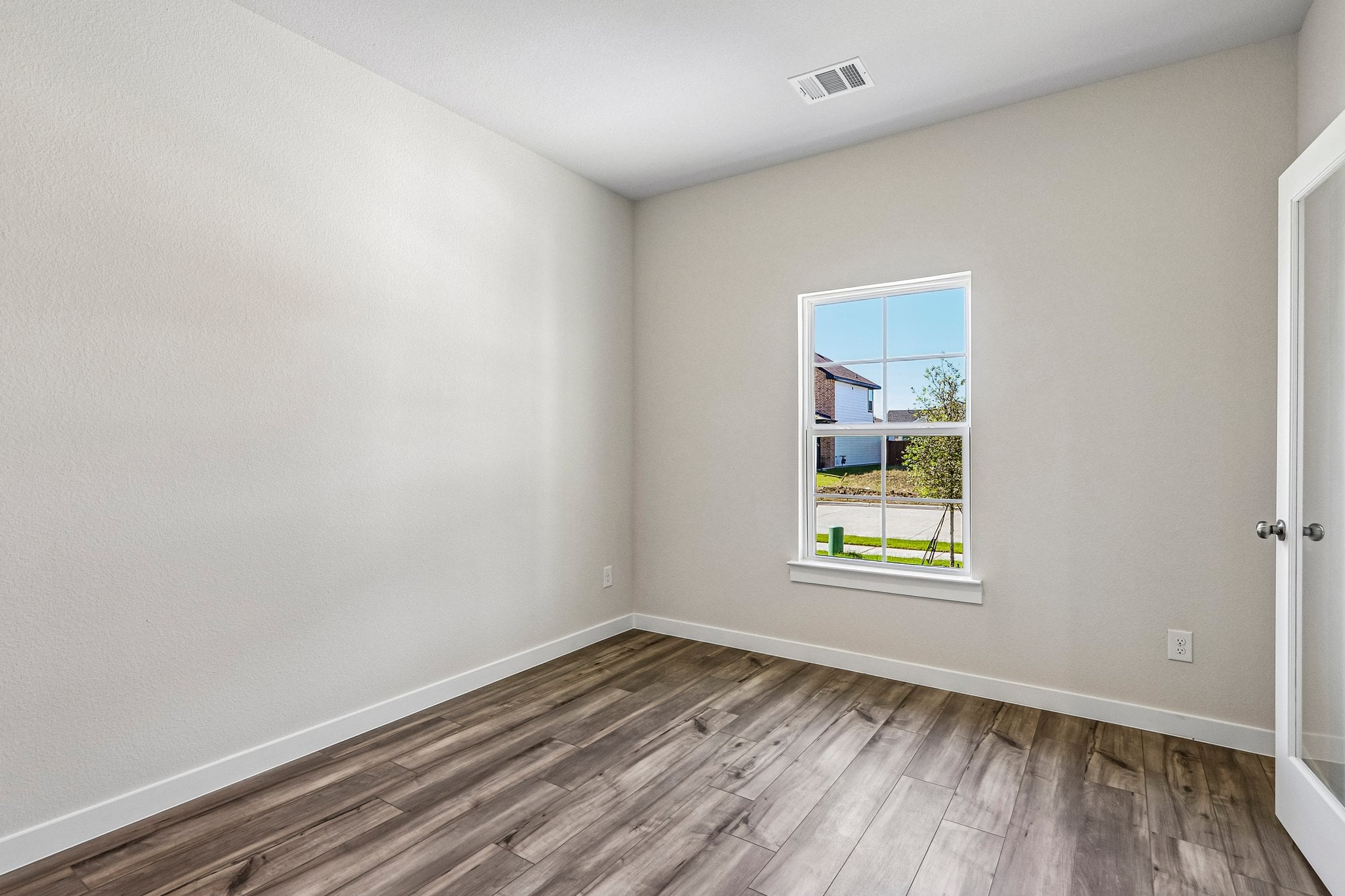A room with a wood floor and a window with a wood floor.