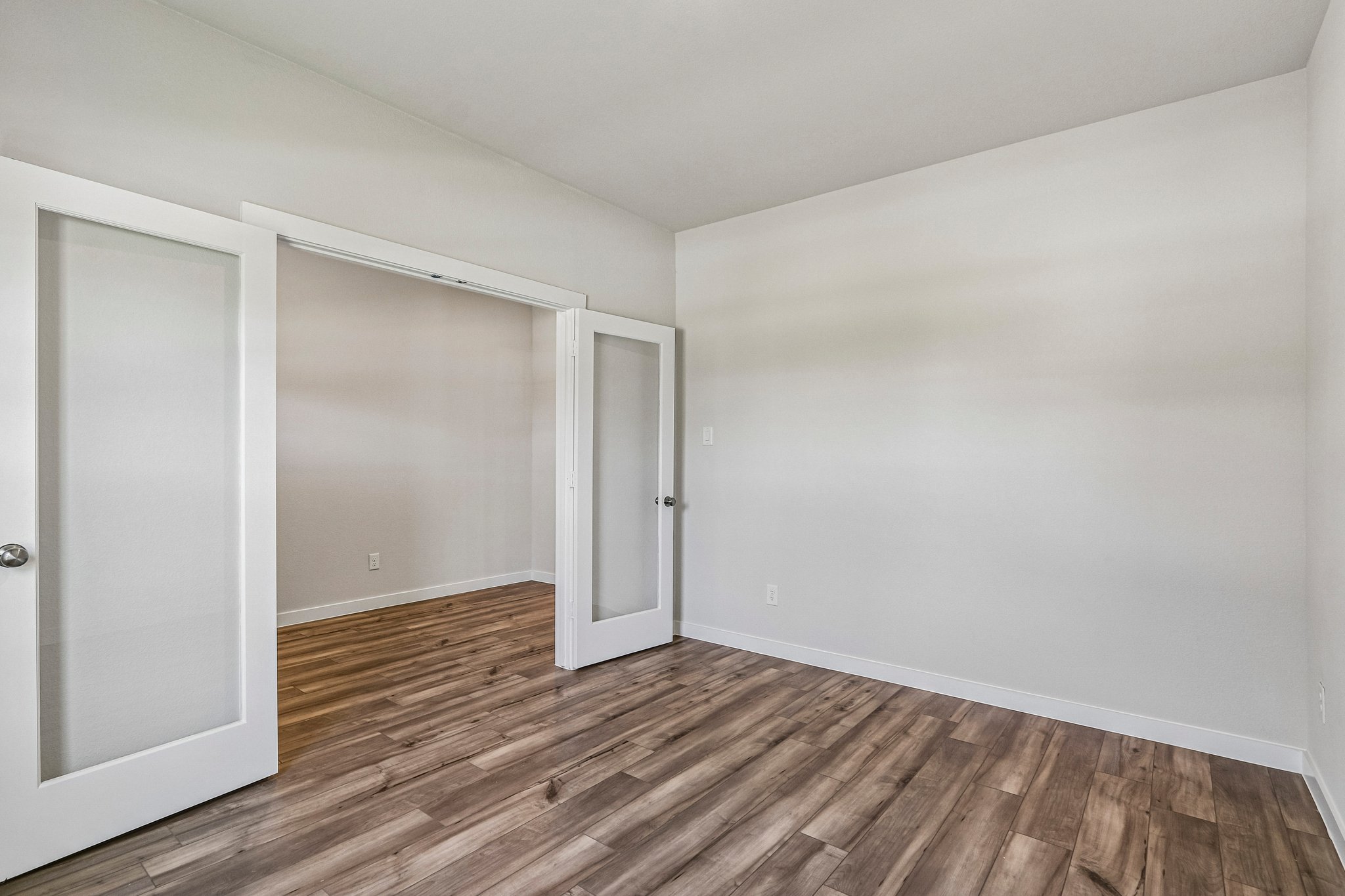 A room with a wood floor and a white door.