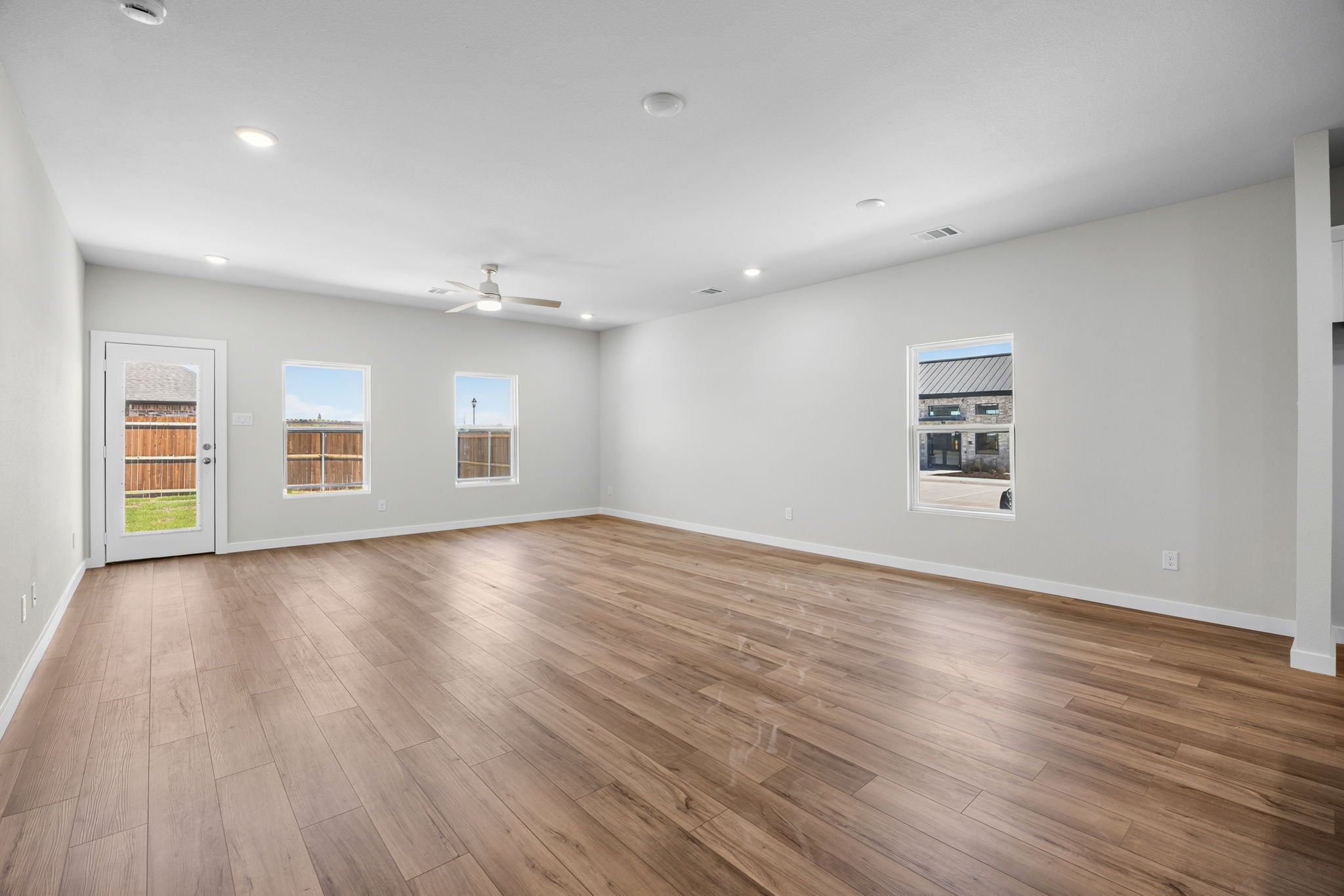 A large empty room with a wood floor and a wood floor.