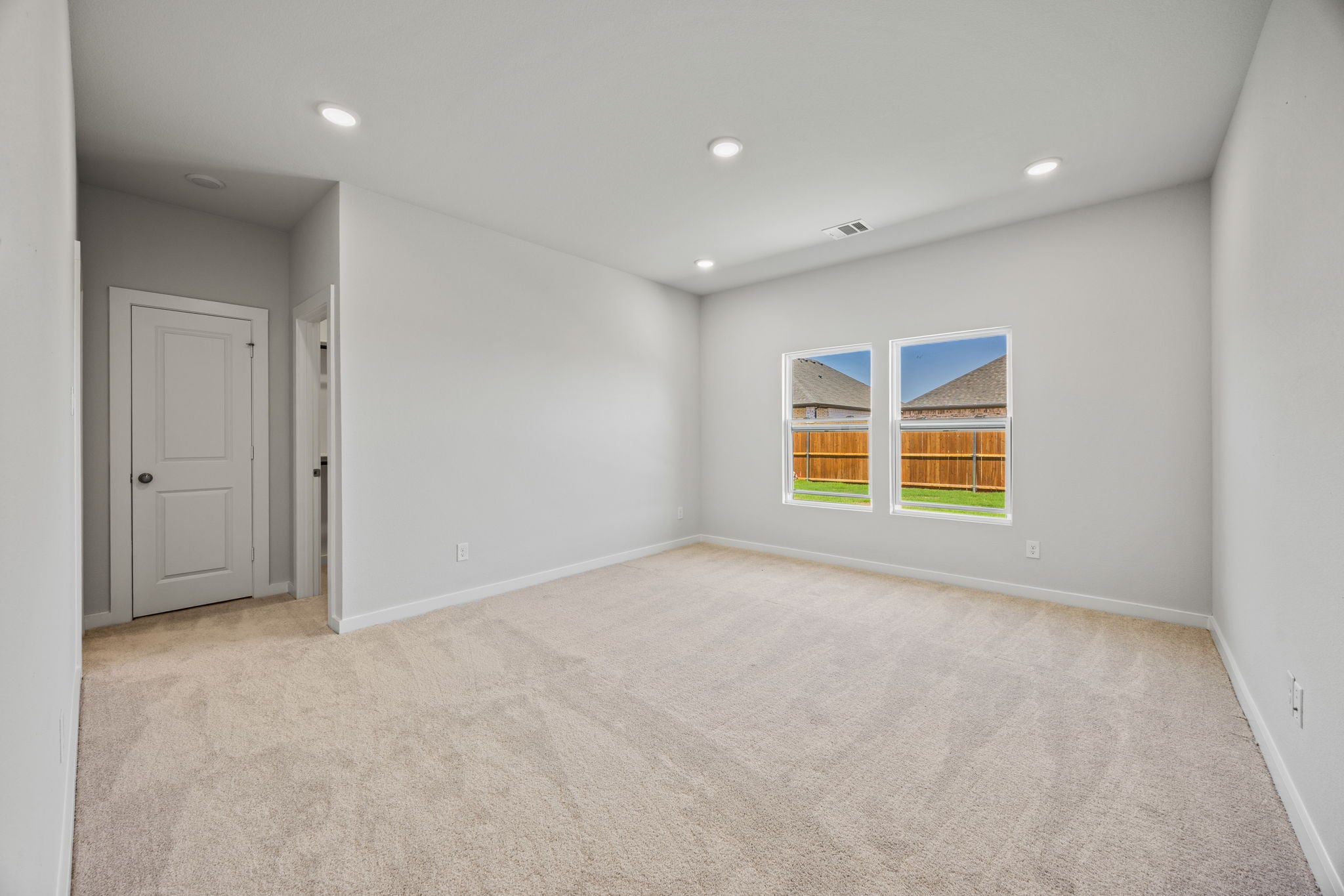 A room with a carpet and windows.