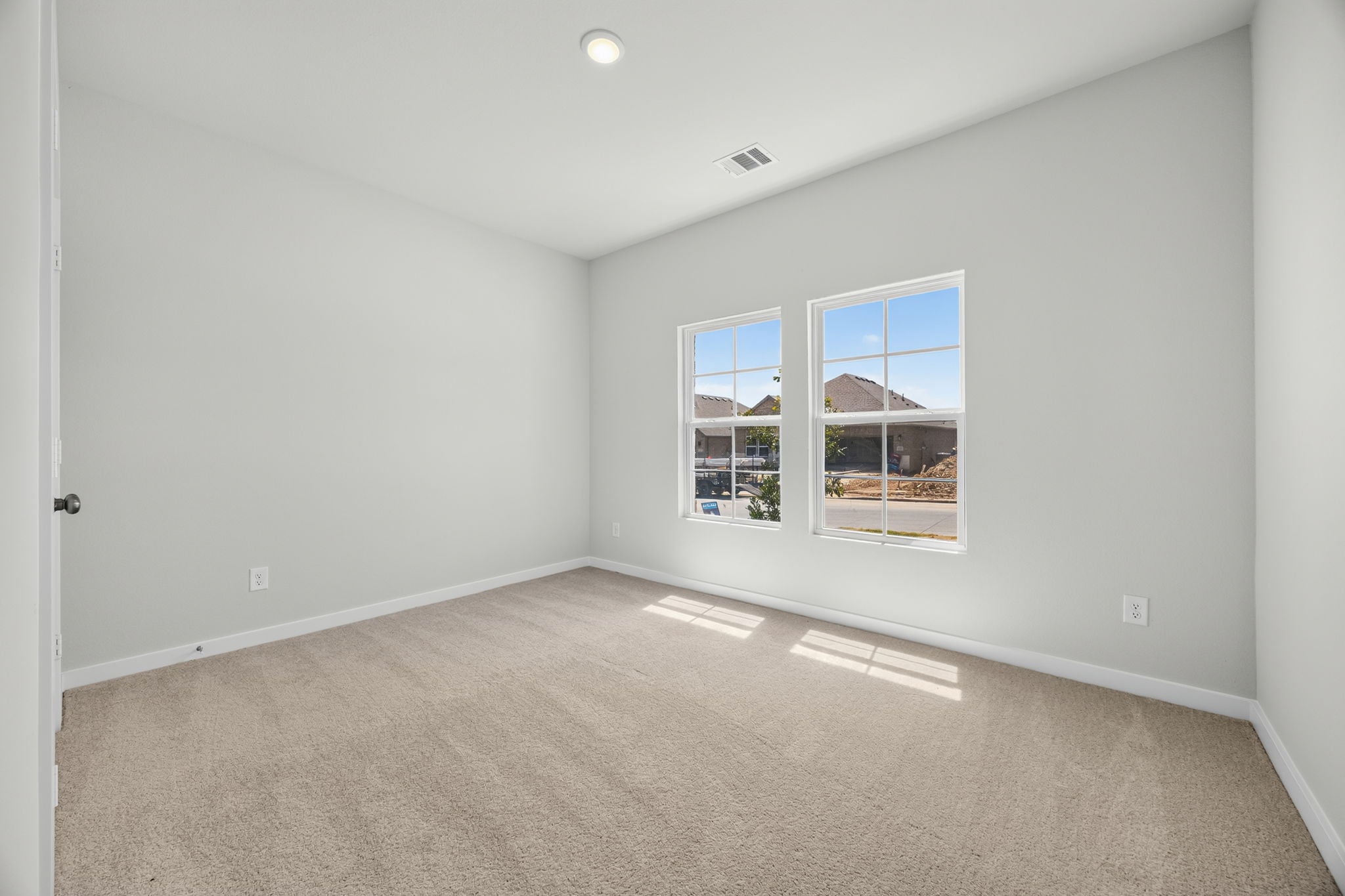 A room with a window and a carpet.