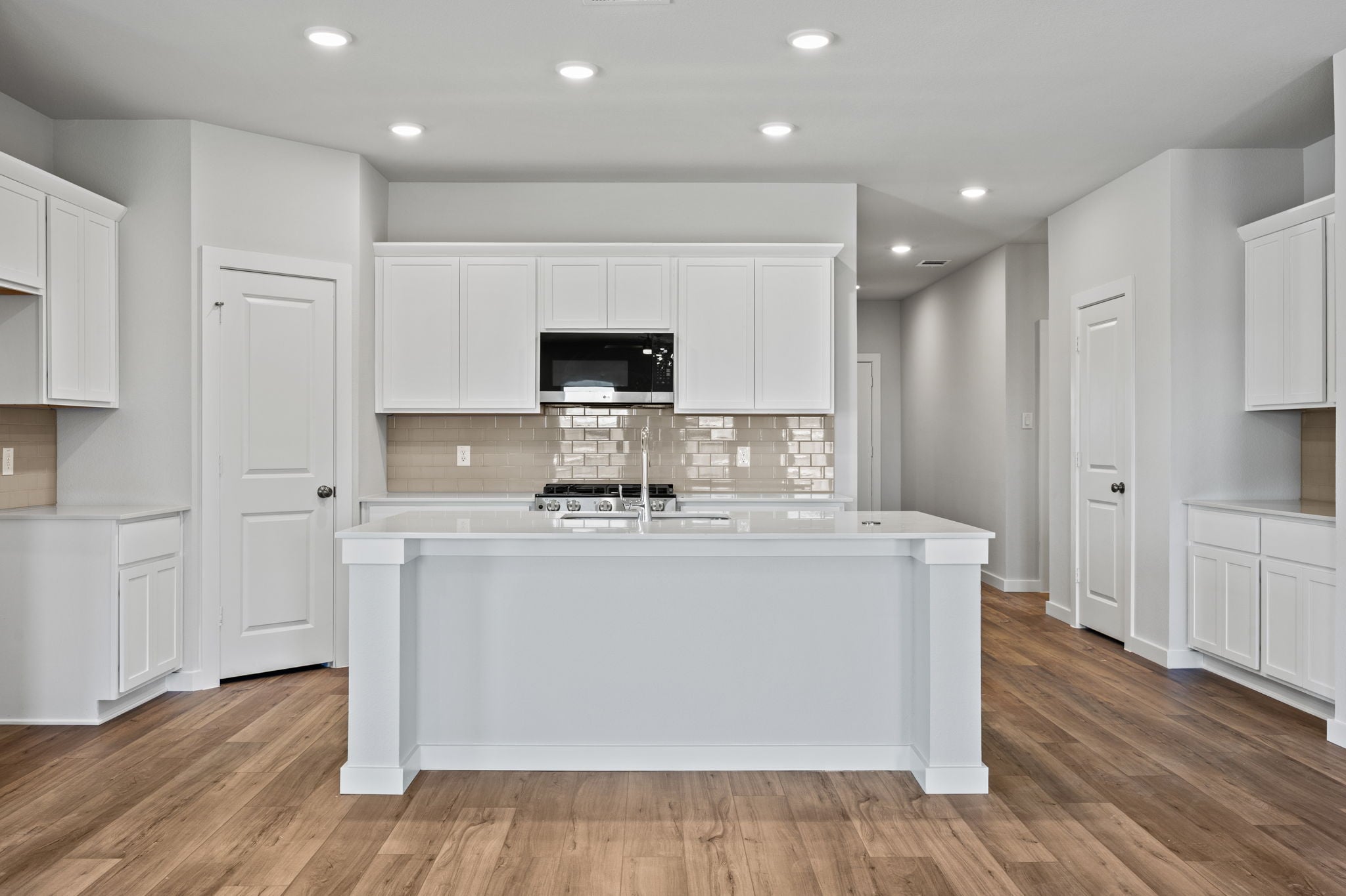 A kitchen with white cabinets.