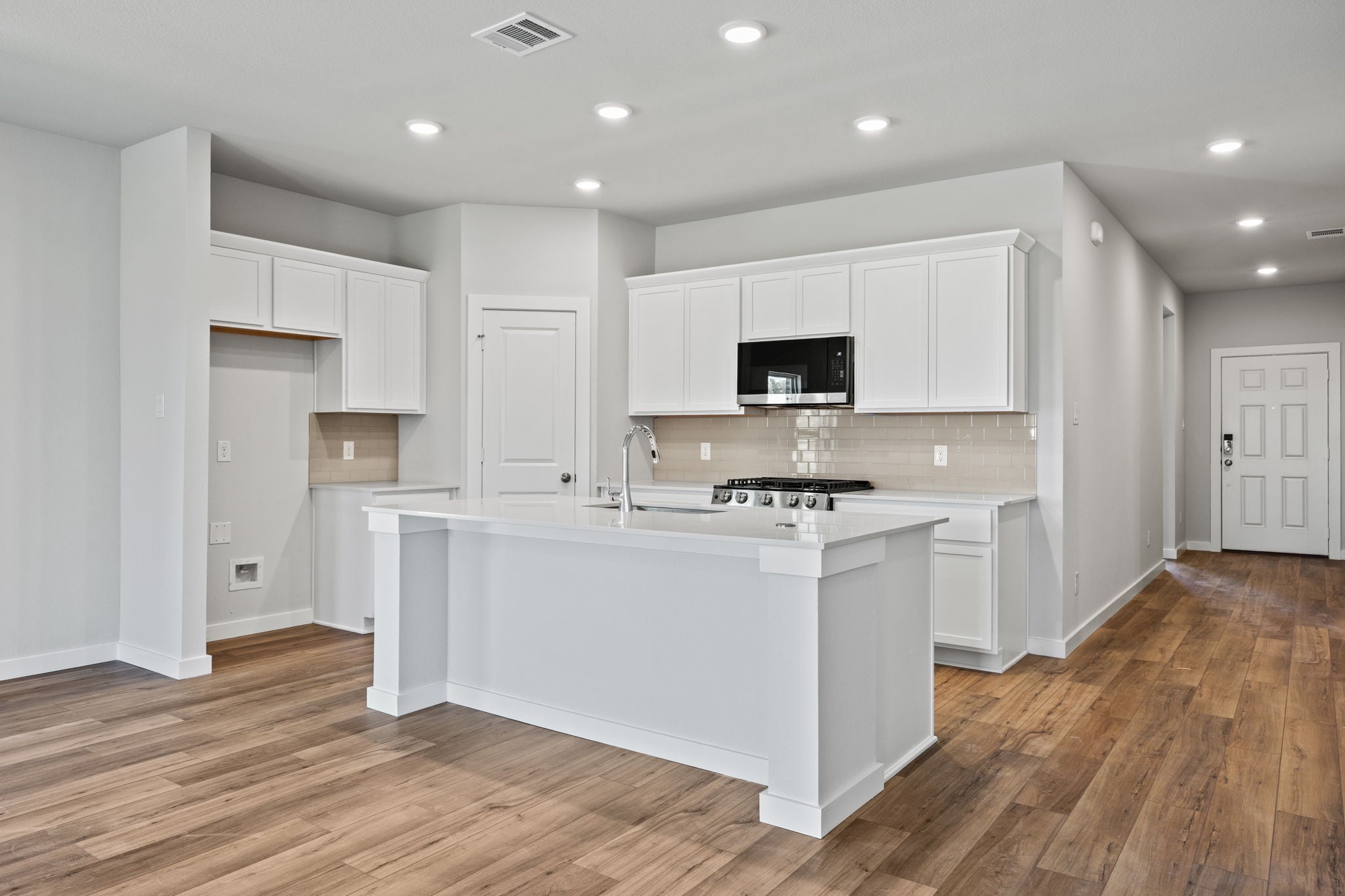 A kitchen with white cabinets.