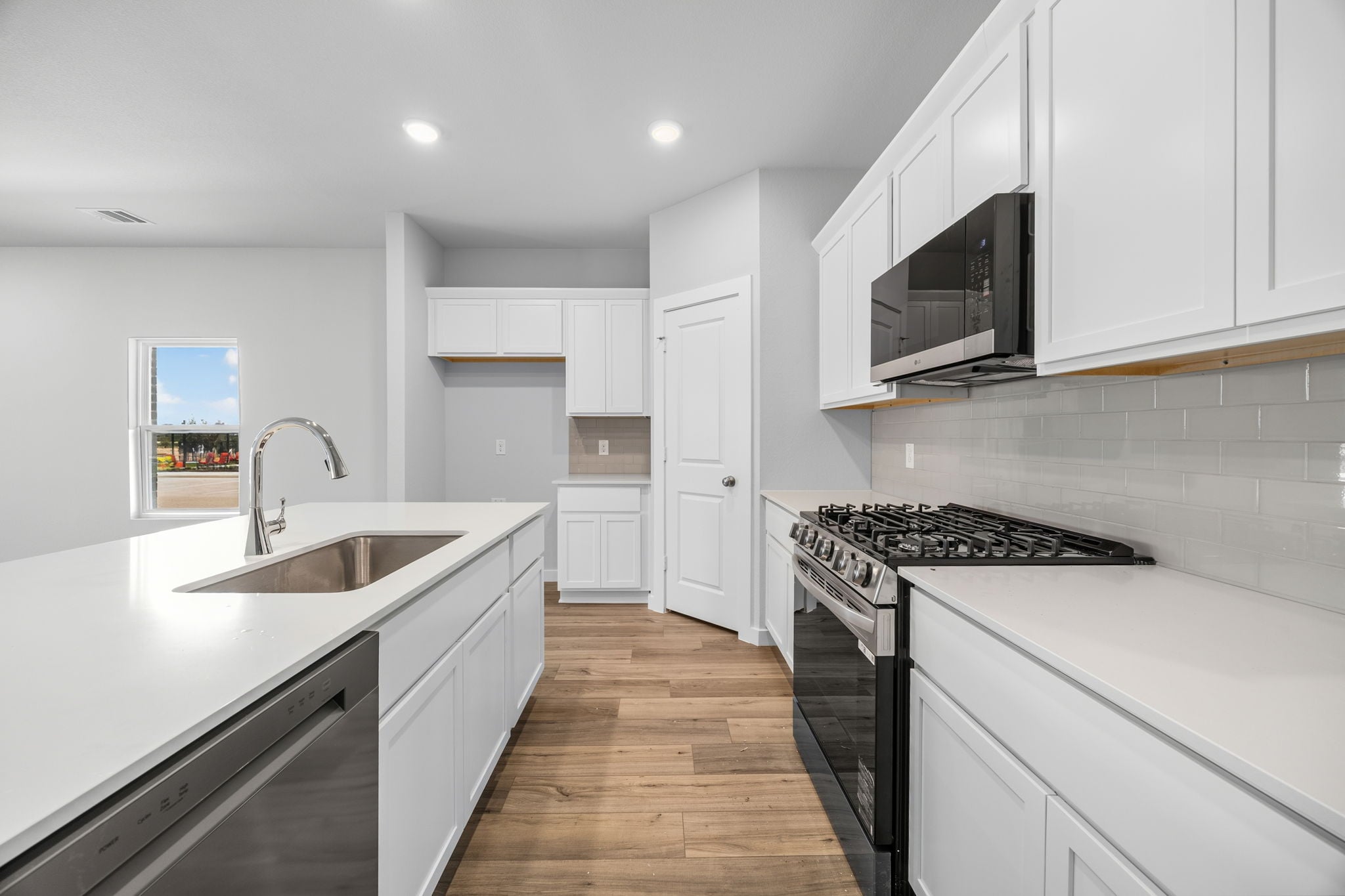 A kitchen with white cabinets.