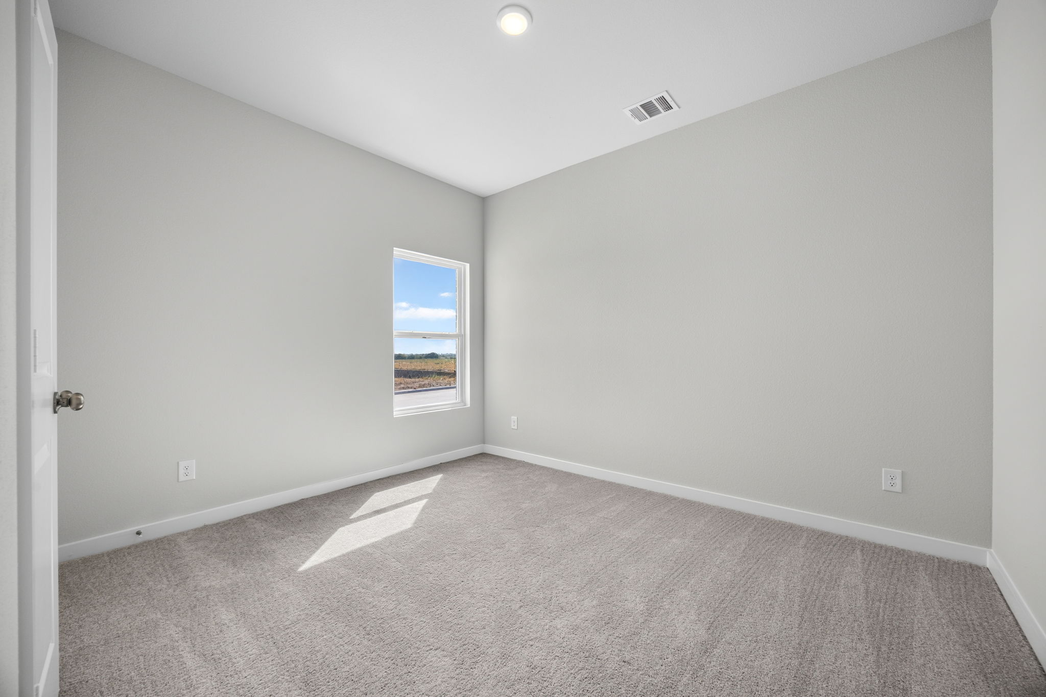 A room with a window and carpet.