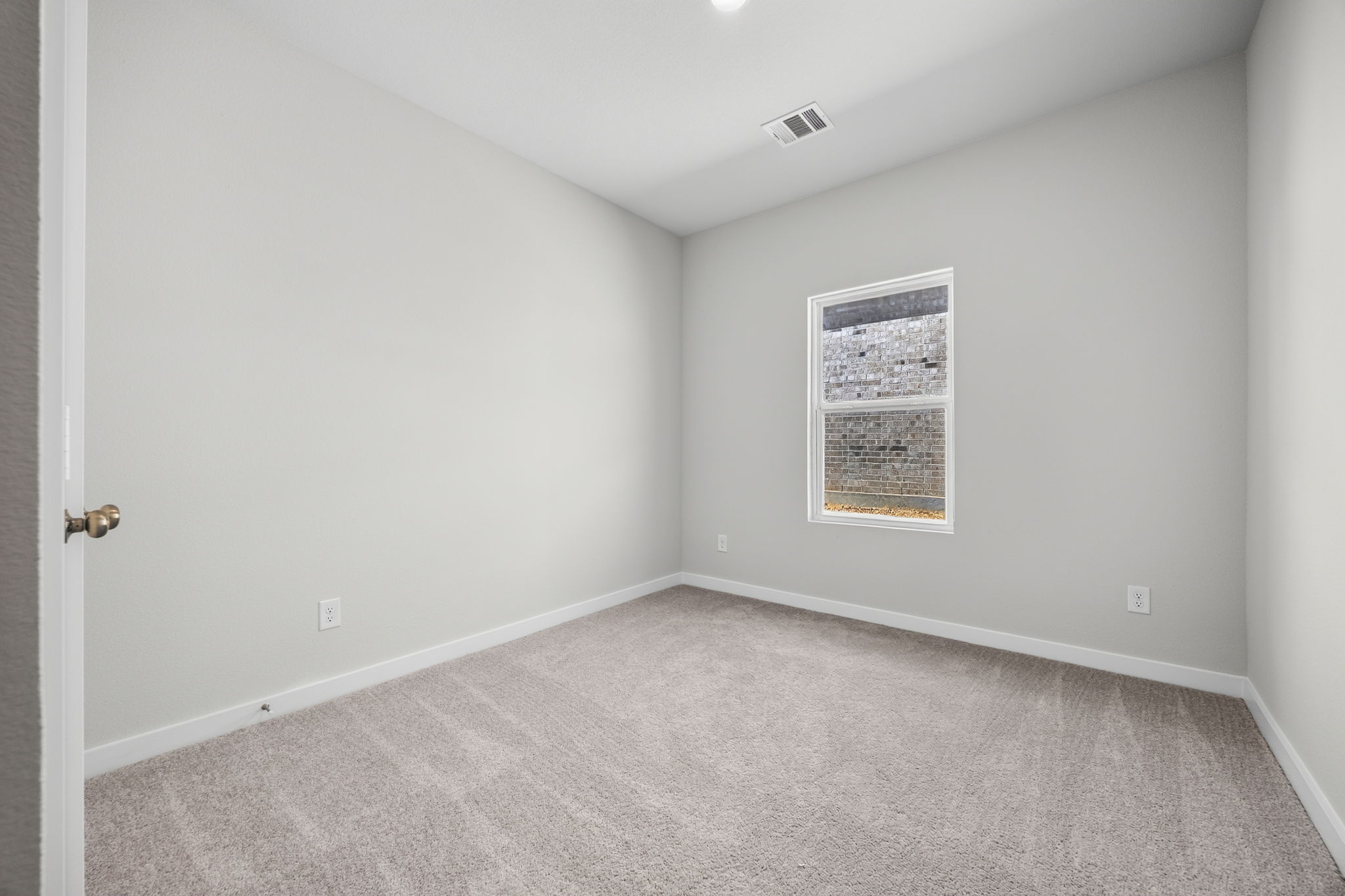 A room with a carpet and a door.