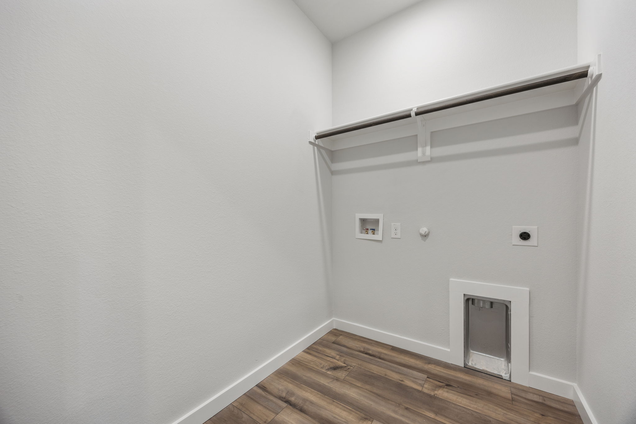A white room with a wood floor.
