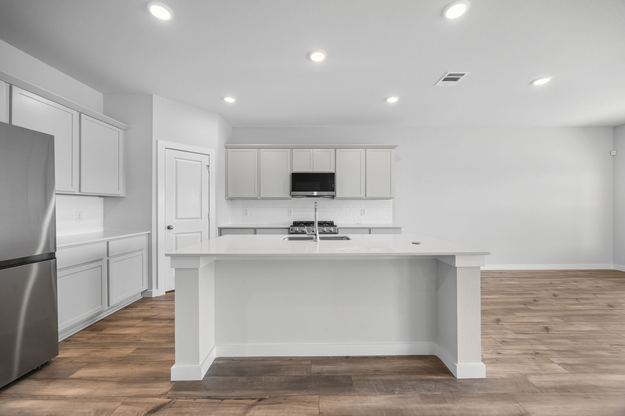 A kitchen with white cabinets.