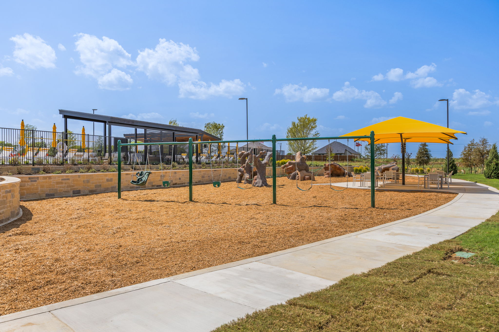 A playground with a yellow umbrella.