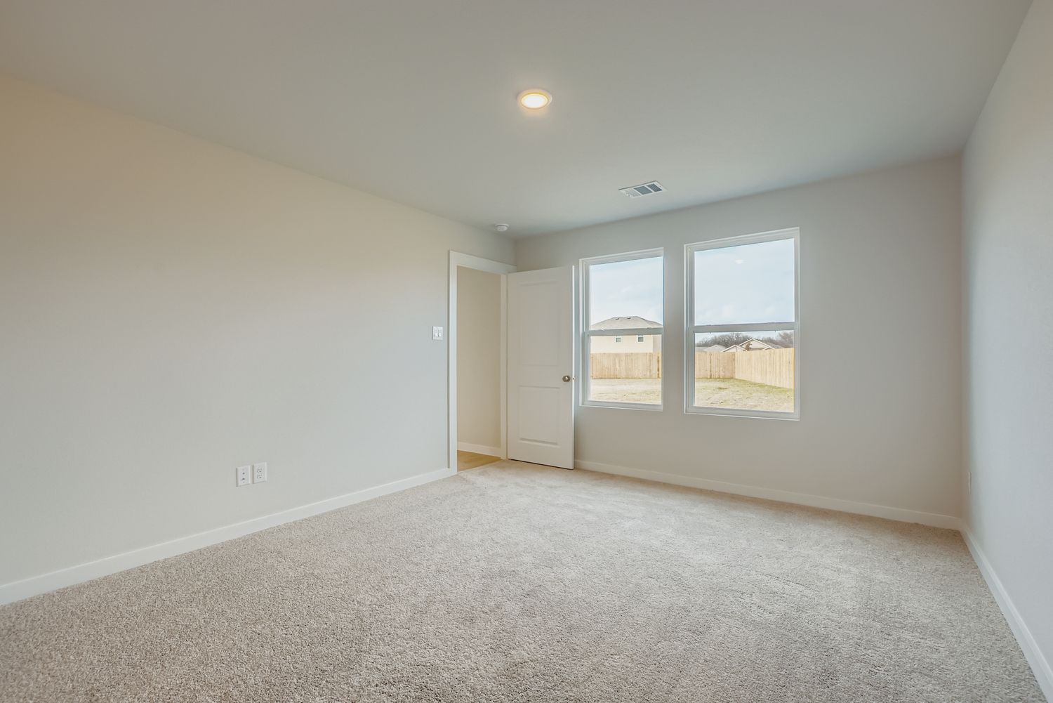 A room with a carpet and windows.