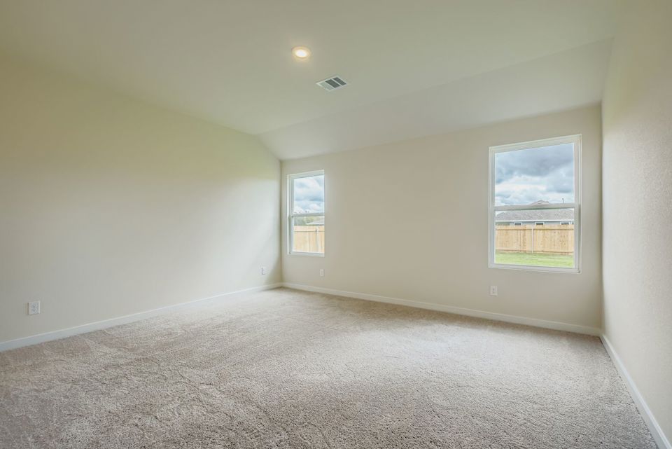 A room with a carpet and a window.