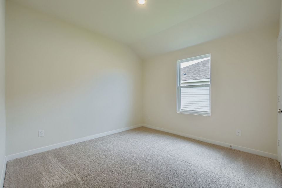 A room with a carpet and a window.
