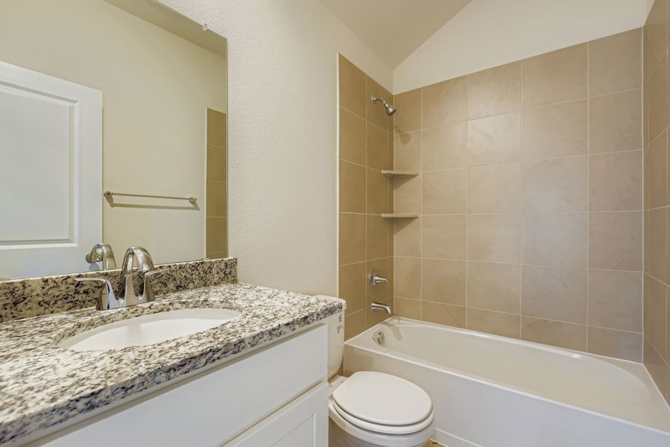 A bathroom with a tub sink and toilet.