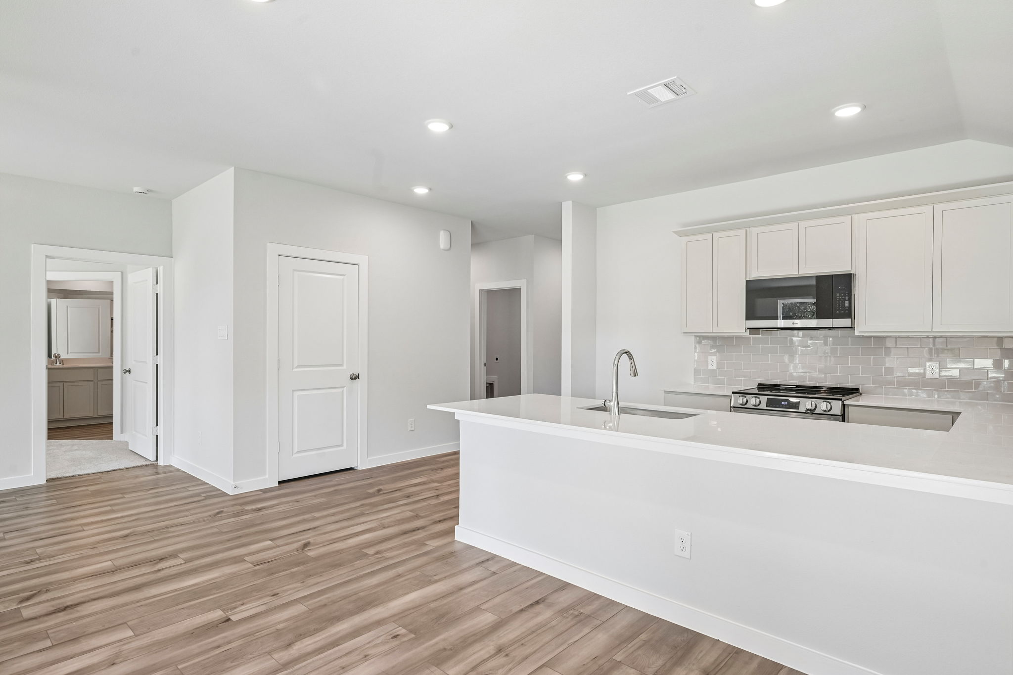 A kitchen with white cabinets.