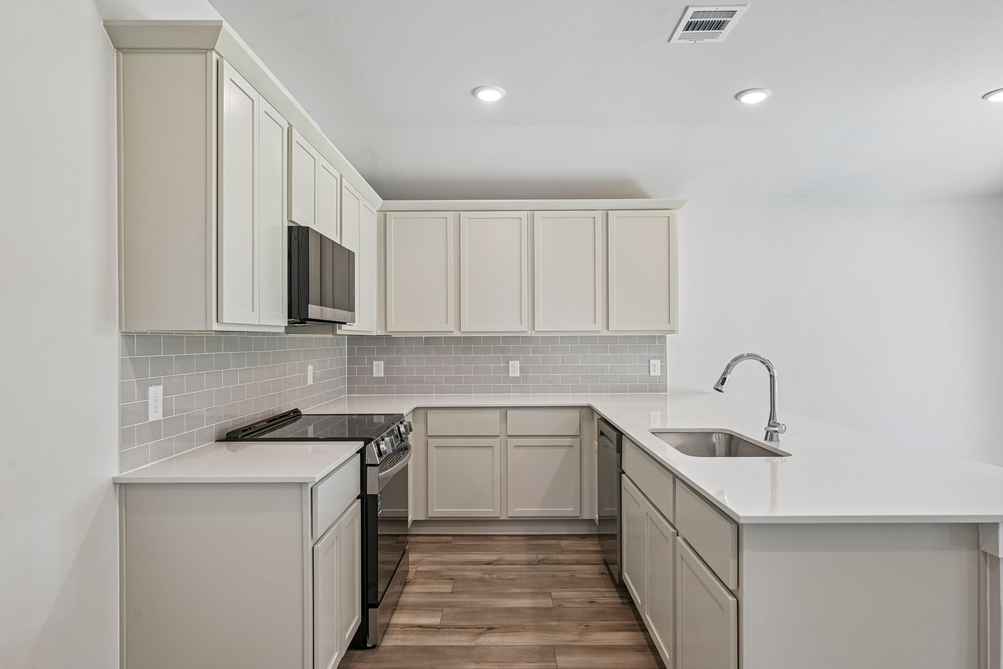 A kitchen with white cabinets.