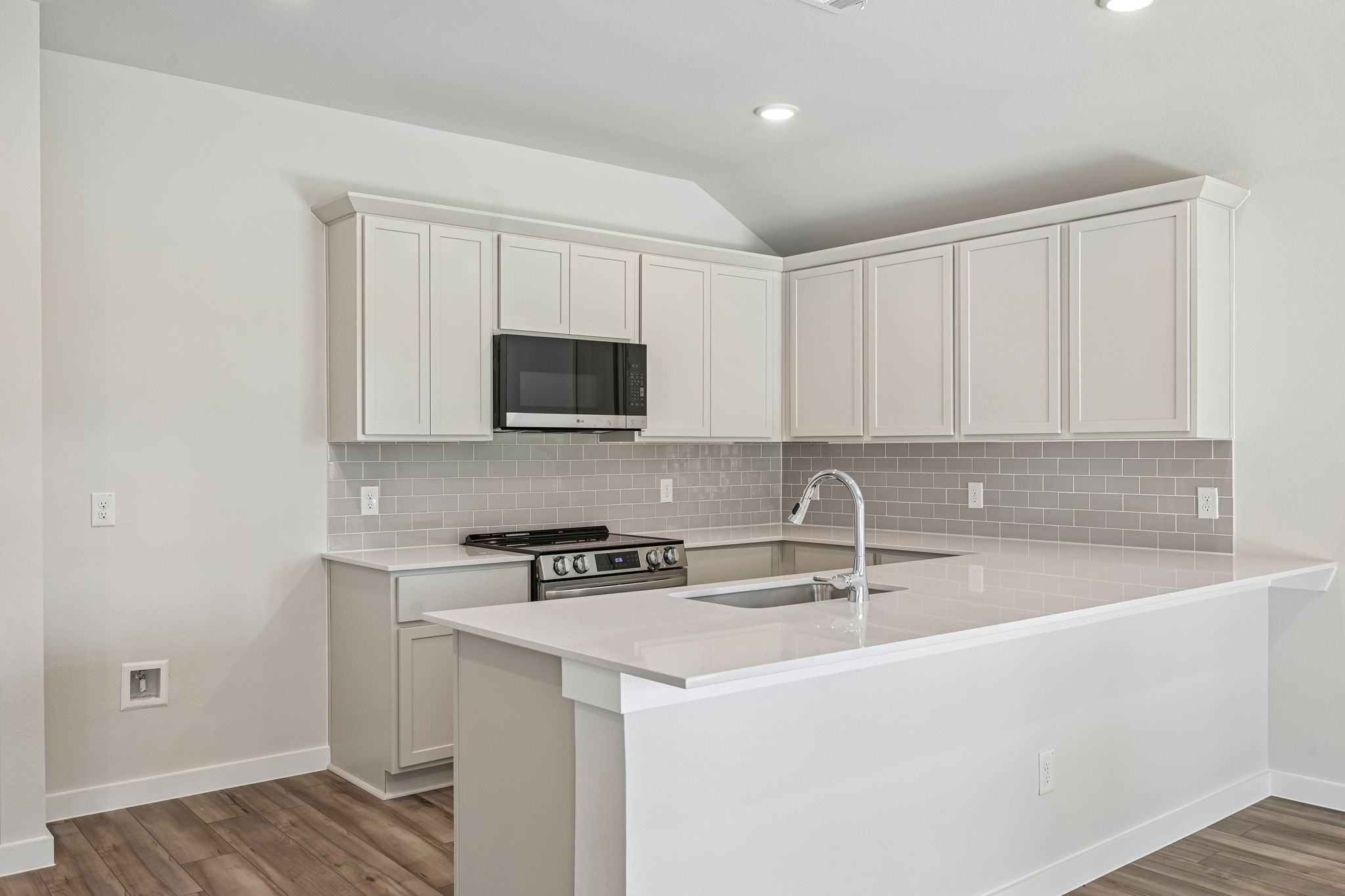 A kitchen with white cabinets.