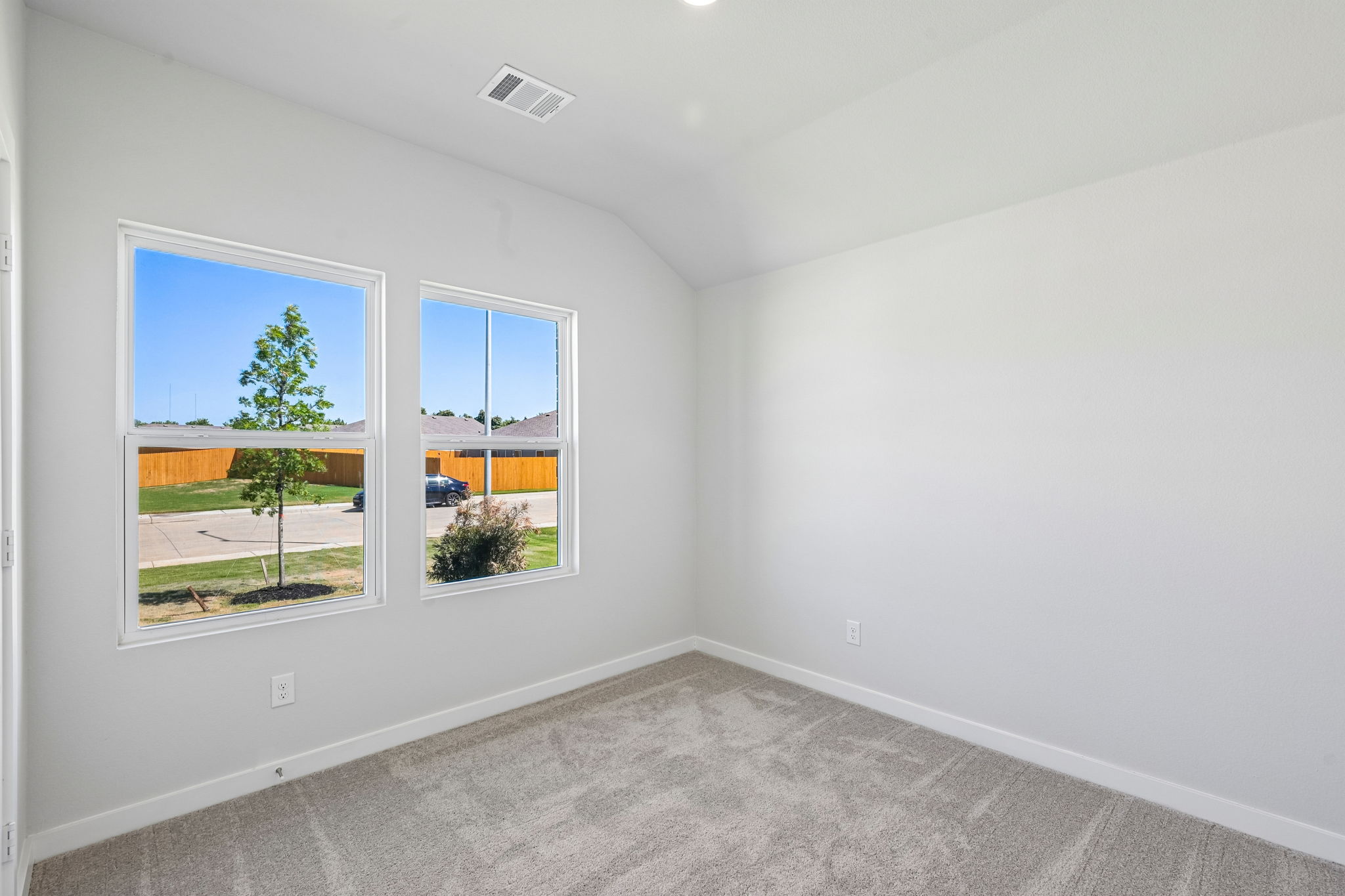 A room with a window and a tree outside.
